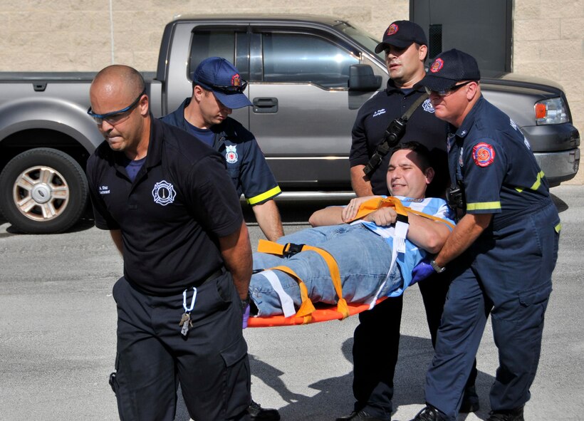 First responders from Homestead Air Reserve Base transport an active shooter participant to a mobile triage during an Active Shooter Exercise at HARB, July 31. The goal of the exercise is to evaluate and improve multiple units’ ability to prepare for and respond to situations such as an active shooter on base. (U.S. Air Force photo/Ross Tweten)