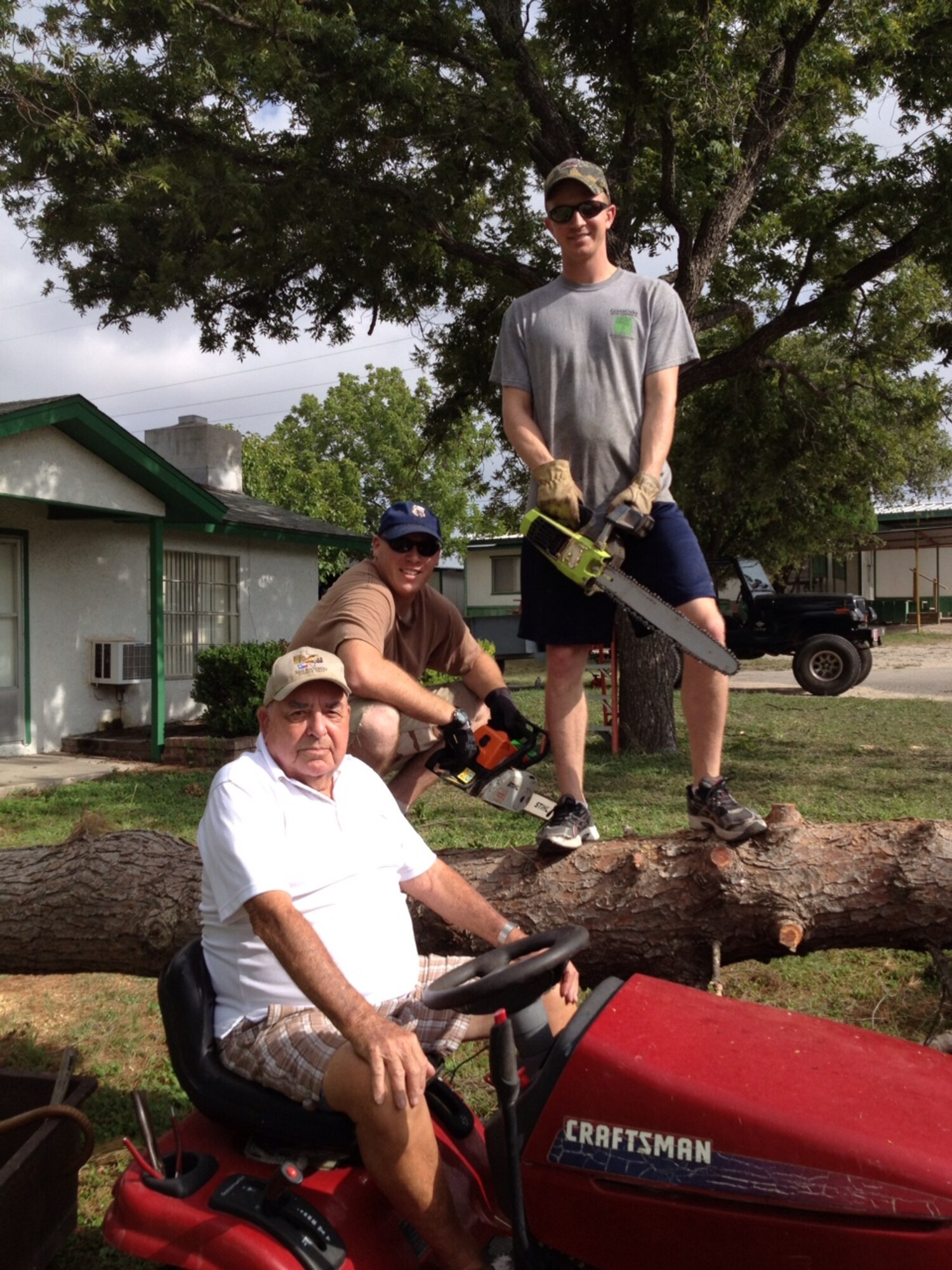 Second Lt. Garret Karnowski and 2nd Lt. Michael Archibald of the 47th Civil Engineer Squadron along with World War II veteran Carl Cooley, pose for a photo atop the tree that had been threatening Cooley’s home in Del Rio, TX July 28, 2012. The pine tree was on the verge of falling onto Cooley’s home when the two lieutenants volunteered to go out and cut down the tree.  (Contributed photo)