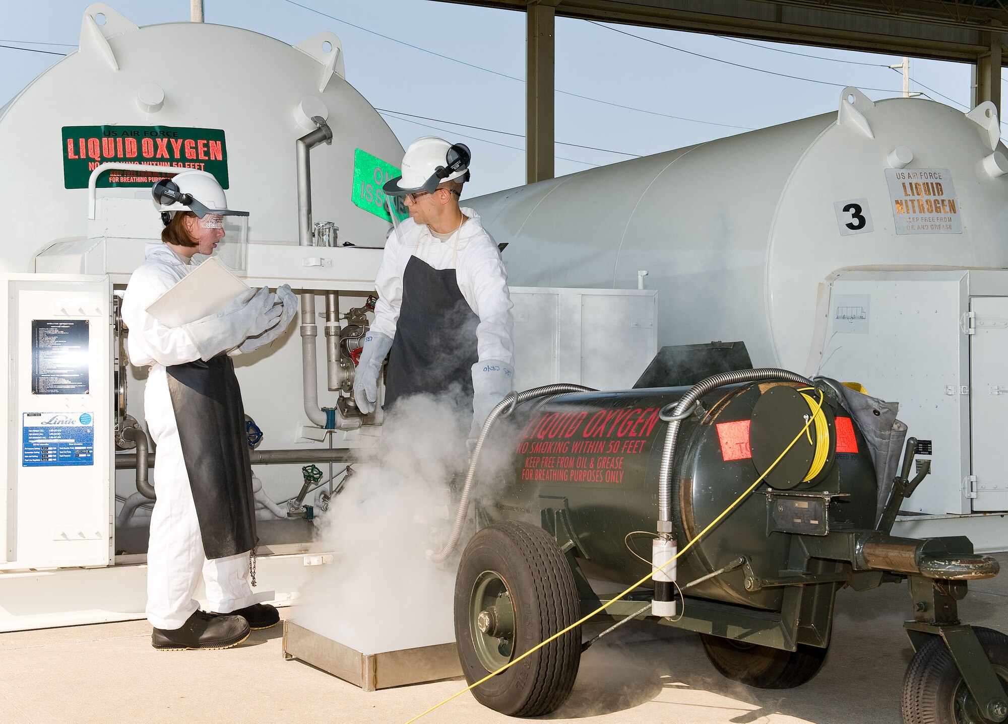 Airman Mackenzie Newman, left, and Airman 1st Class Lyric Ester, both cryogenics facilities specialists with the 436th Logistics Readiness Squadron, service a liquid oxygen cart in the cryogenics servicing yard Aug. 2, 2012, at Dover Air Force Base, Del. The cryogenics facility is responsible for supplying, storing and quality-testing liquid oxygen and liquid nitrogen for use at Dover AFB.  (U.S. Air Force photo by Roland Balik)