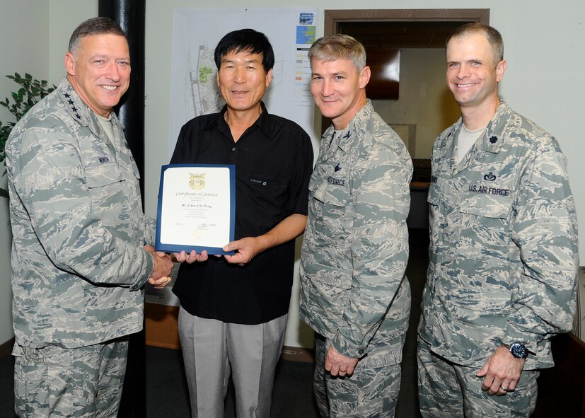 Gen. Gary  North, Pacific Air Forces commander, along with Col. John Pearse, 8th Fighter Wing commander, and Lt Col. Deron Frailie, 8th Civil Engineer Squadron commander, awards Choe Chi Pong, 8th Civil Engineer Squadron general supply specialist, with a certificate of service for his 30 years of service at Kunsan Air Base, Republic of Korea, July 18, 2012. One of five civilians awarded this honor by North, Choe worked for his first four years at Kunsan’s 8th Logistics Readiness Squadron as a supply clerk before moving to the 8th Civil Engineer Squadron’s material control office.  (U.S. Air Force photo/Senior Airman Marcus Morris)