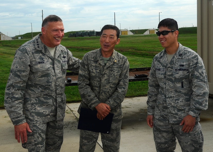 Gen. Gary North, Pacific Air Forces commander, and Capt. Hoyoon Chung, right, 8th Maintenance Squadron mission flight commander, congratulate Hong Kwon, 8th Maintenance Squadron explosive operator, for 30 years of service at Kunsan Air Base, Republic of Korea, July 18, 2012. Kwon is one of five civilians who were awarded this honor by North. (U.S. Air Force photo/Senior Airman Marcus Morris)