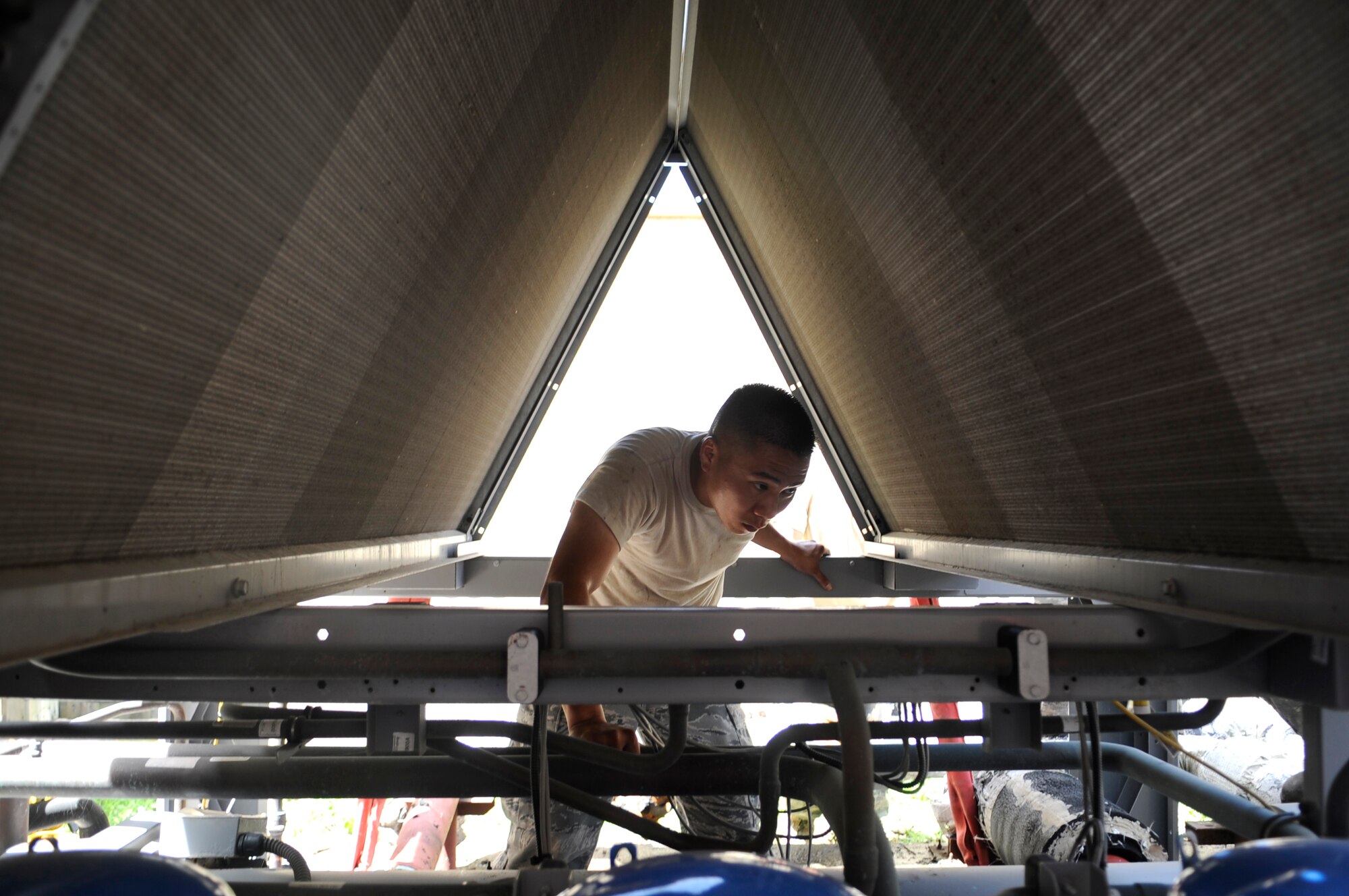 Tech. Sgt. Clement Cheung, 8th Civil Engineer Squadron heating, ventilation and air conditioning technician, installs a new chiller at a dormitory at Kunsan Air Base, Republic of Korea, July 30, 2012. To install the new 2.5-ton unit, the HVAC shop coordinated with CES electricians and heavy equipment operators to get the job done. (U.S. Air Force photo/Senior Airman Brigitte N. Brantley)