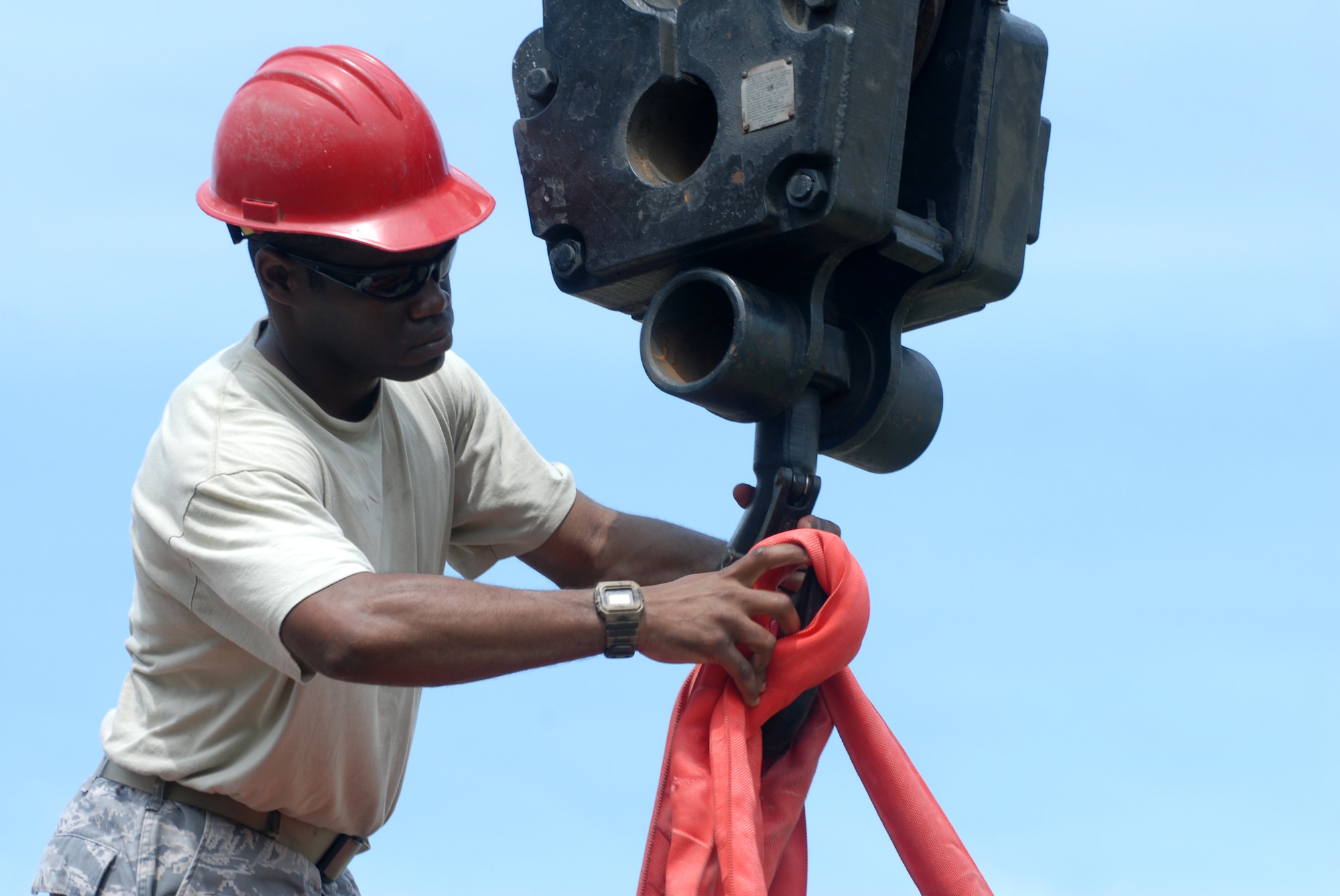 Tech. Sgt. Andrew Wallace, 8th Civil Engineer Squadron pavements and equipment NCO in charge, attaches straps to a new air conditioner July 30, 2012, at Kunsan Air Base, Republic of Korea. Replacing the unit was a coordinated effort between multiple CES shops. (U.S. Air Force photo/Senior Airman Brigitte N. Brantley)