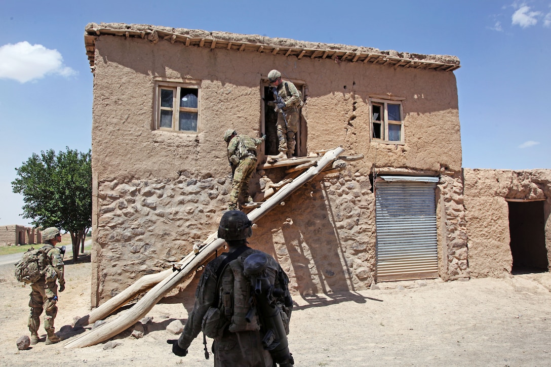 U.S. soldiers exit an upstairs door after searching a house in Pana village in Afghanistan's Ghazni province, July 24, 2012.