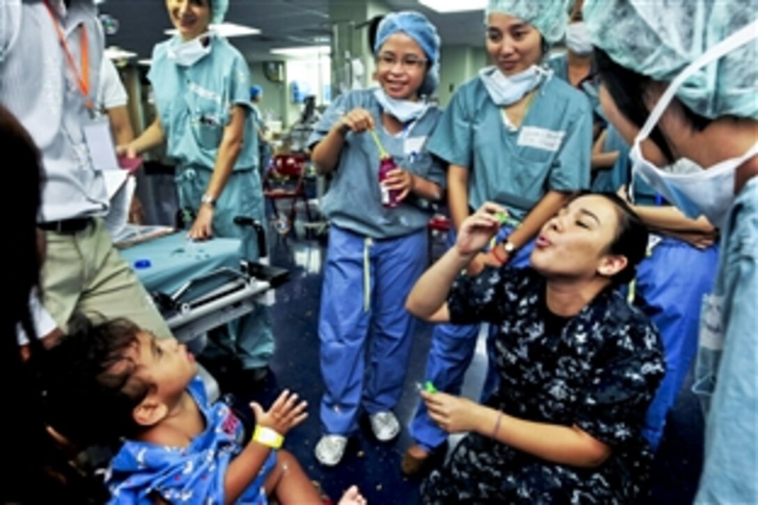 U.S. Navy Petty Officer 3rd Class Priscilla Saintcyr blows bubbles for a Cambodian boy before surgery aboard the Military Sealift Command hospital ship USNS Mercy during Pacific Partnership 2012 in Sihanoukville, Cambodia, Aug. 1, 2012. Cambodia is the final port for Pacific Partnership 2012, an annual U.S. Pacific Fleet humanitarian and civic assistance mission. Previous stops included Indonesia, the Philippines and Vietnam.