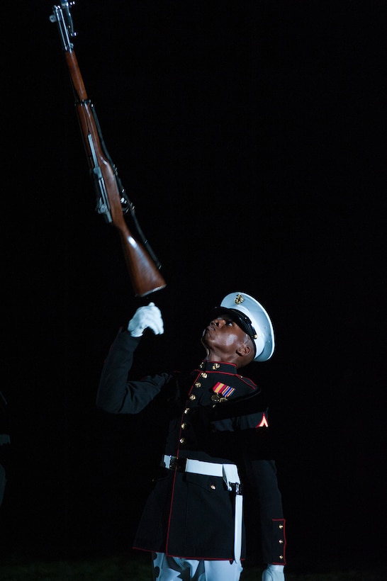 Lance Cpl. Wayne McIntosh, Silent Drill Platoon member, tosses his M1 Garand rifle in the air during a special Friday Evening Parade at Marine Barracks Washington Aug. 3. Sgt. Maj. Micheal P. Barrett, sergeant major of the Marine Corps, served as the hosting official for this parade, which featured staff noncommissioned officers in positions traditionally held by officers.