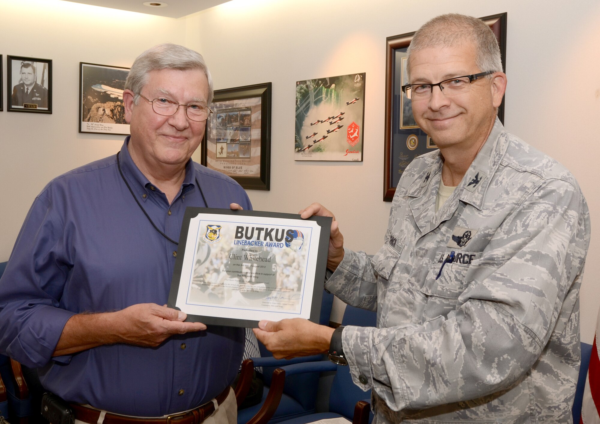 Clinton Whitehead, of the 94th Airlift Wing Communications Squadron, receives the Chief Master Sgt. John M. Anderson Linebacker Award in honor of his 19 years of dedicated service providing information and communication support to Dobbins Air Reserve Base. Whitehead, a retired chief master sgt., has served Dobbins ARB as a contract manager and a civil servant. (U. S. Air Force photo/Brad Fallin)