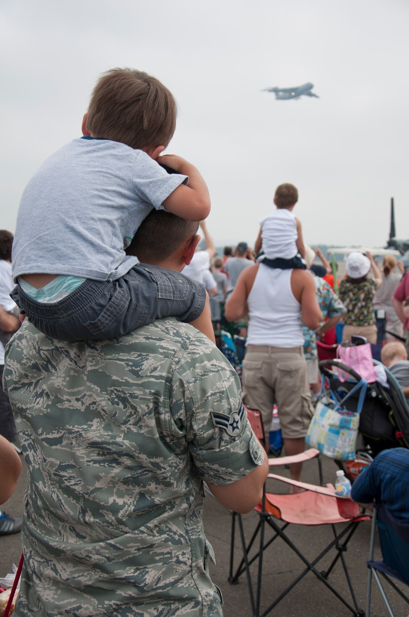 Members of the 439th Airlift Wing and thousands of people from all around New England watch as the C-5 emerges from the clouds in an instrument-only approach to kick off the Great New England Air Show. (U.S. Air Force Photo by SrA Alexander Brown)
