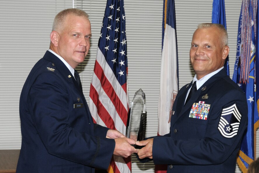 Col. Drew DeHaes (left) presents Chief Master Sgt. Timothy Cochran (right) with his award as he accepts responsibility of Command Chief Master Sgt. of the 132nd Fighter Wing (132FW), Des Moines, Iowa at his Change of Responsibility ceremony held in the Dining Facility of the 132FW on August 4, 2012.  (US Air Force Photo/Staff Sgt. Linda E. Kephart)(Released)