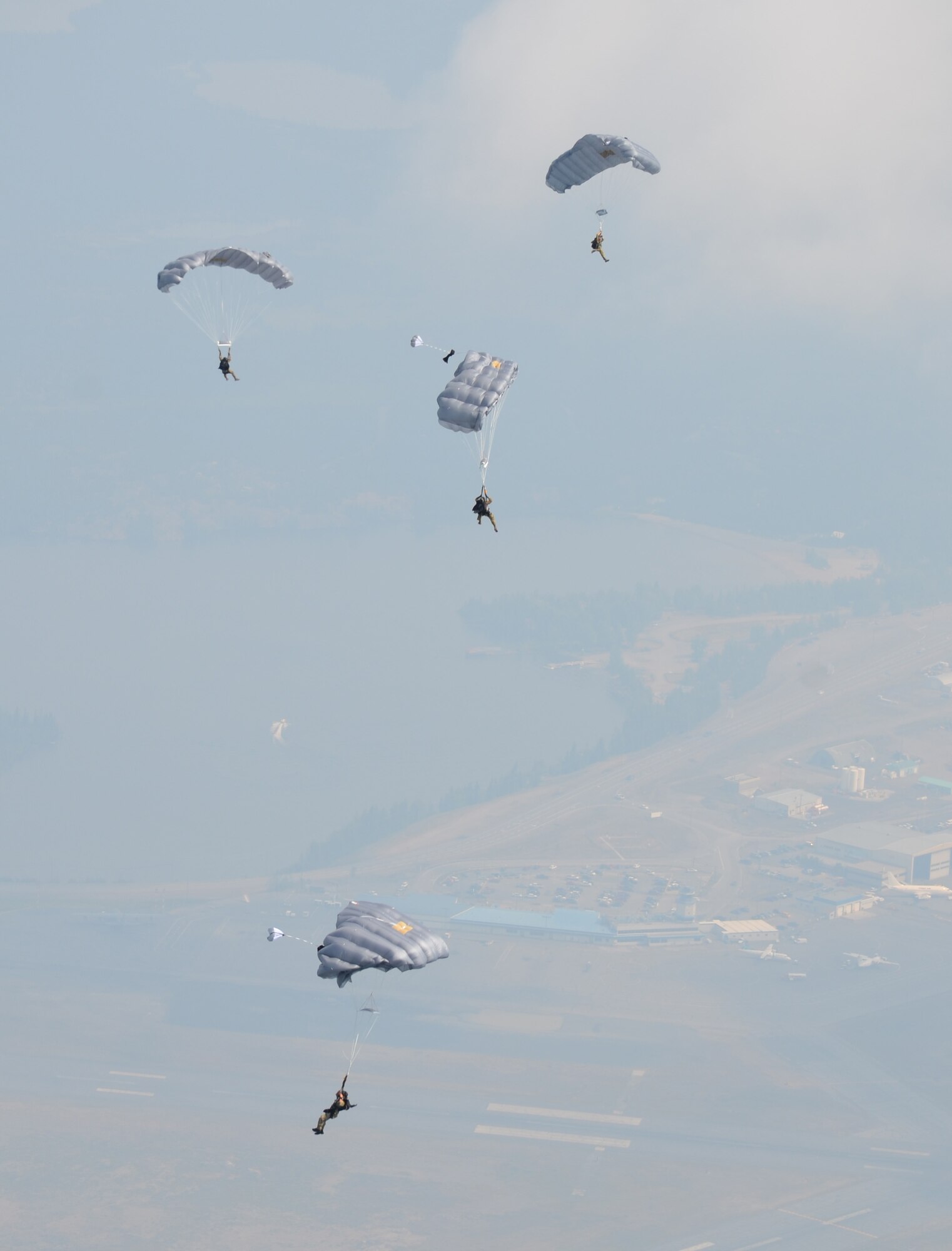Pararescuemen from the 308th Rescue Squadron parachute toward a drop zone in Yellowknife, Canada, July 17, 2012. The PJs had just performed a static-line jump from a Canadian Royal Air Force C-130 as part of an exercise with Canadian search-and-rescue technicians. (U.S. Air Force photo/Staff Sgt. Anna-Marie Wyant) 
