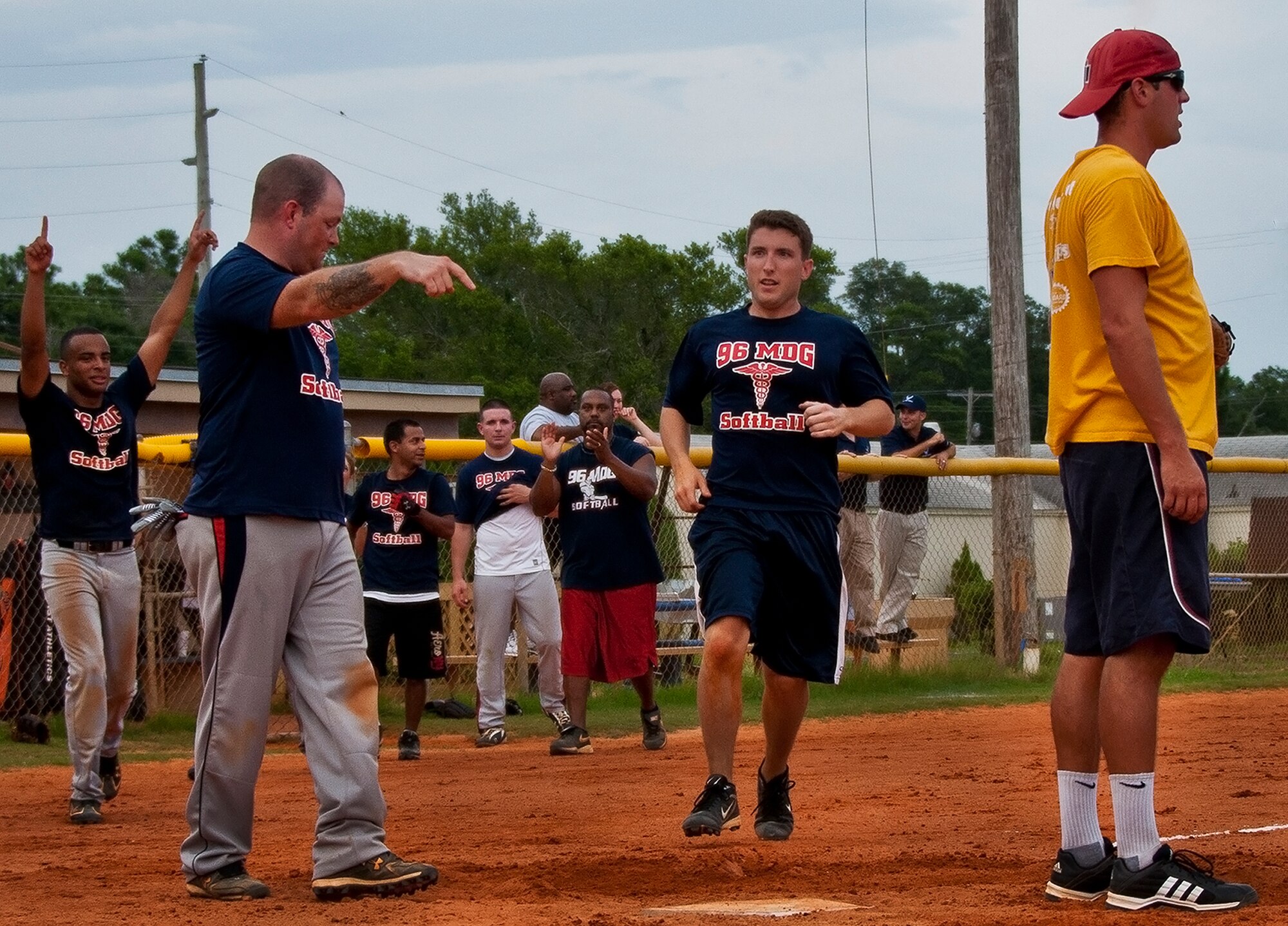 Tate Maples strides toward home for the winning run as his 96th Medical Group teammates react to taking the intramural softball championship Aug. 2 at Eglin Air Force Base, Fla.  MDG won the championship beating the Armament Directorate in final inning 7-6.  (U.S. Air Force photo/Samuel King Jr.)