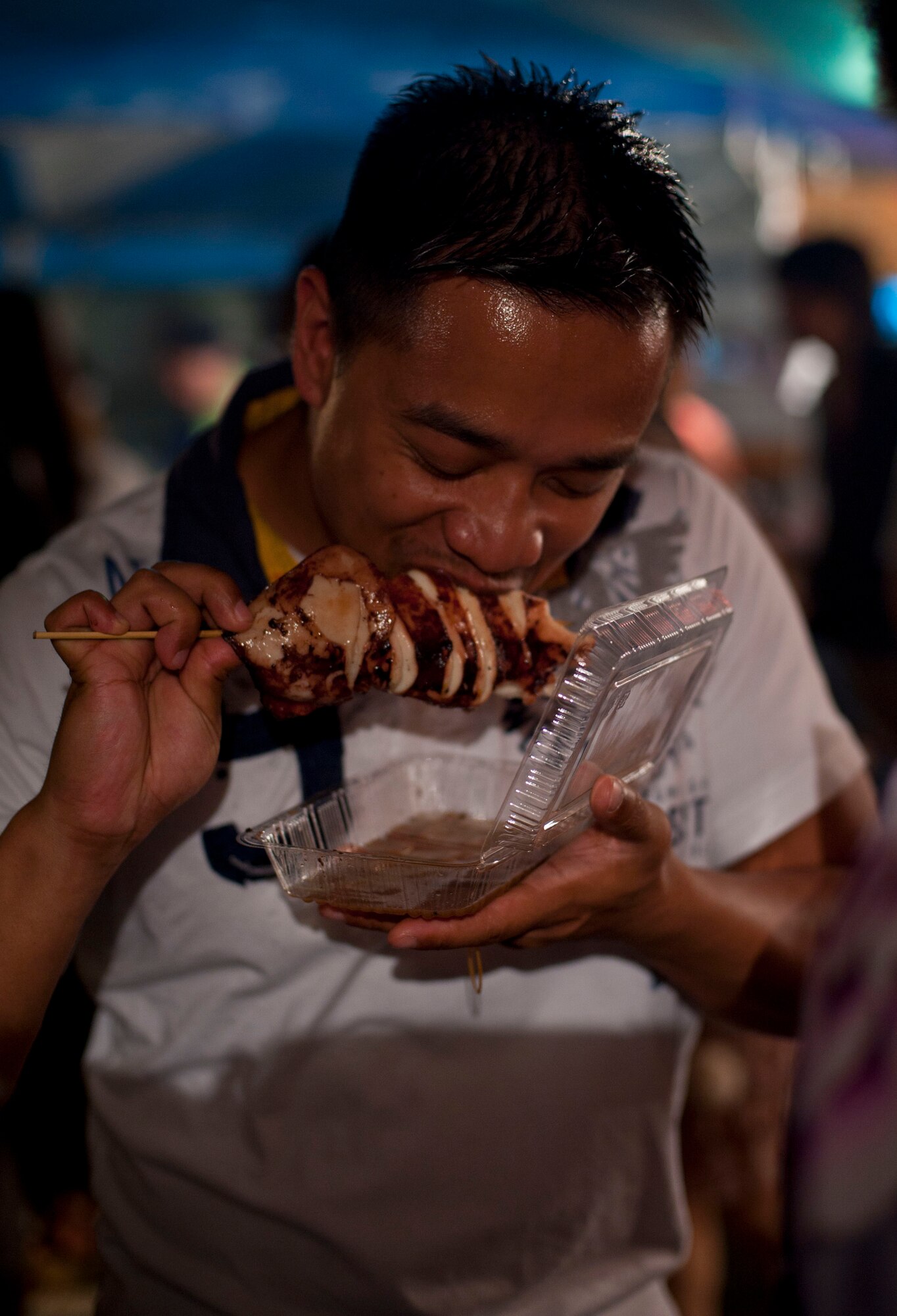 FUSSA CITY, Japan -- Staff Sgt. Darril Posas, 374th Communication Squadron NCO in charge of network applications, tries squid on a stick for the first time while attending the Tanabata Festival in Fussa City, Japan, August 4, 2012. "The taste was different, but I would definitely have it again," Posas said.  (U.S. Air Force photo by Airman 1st Class Krystal M. Garrett) 