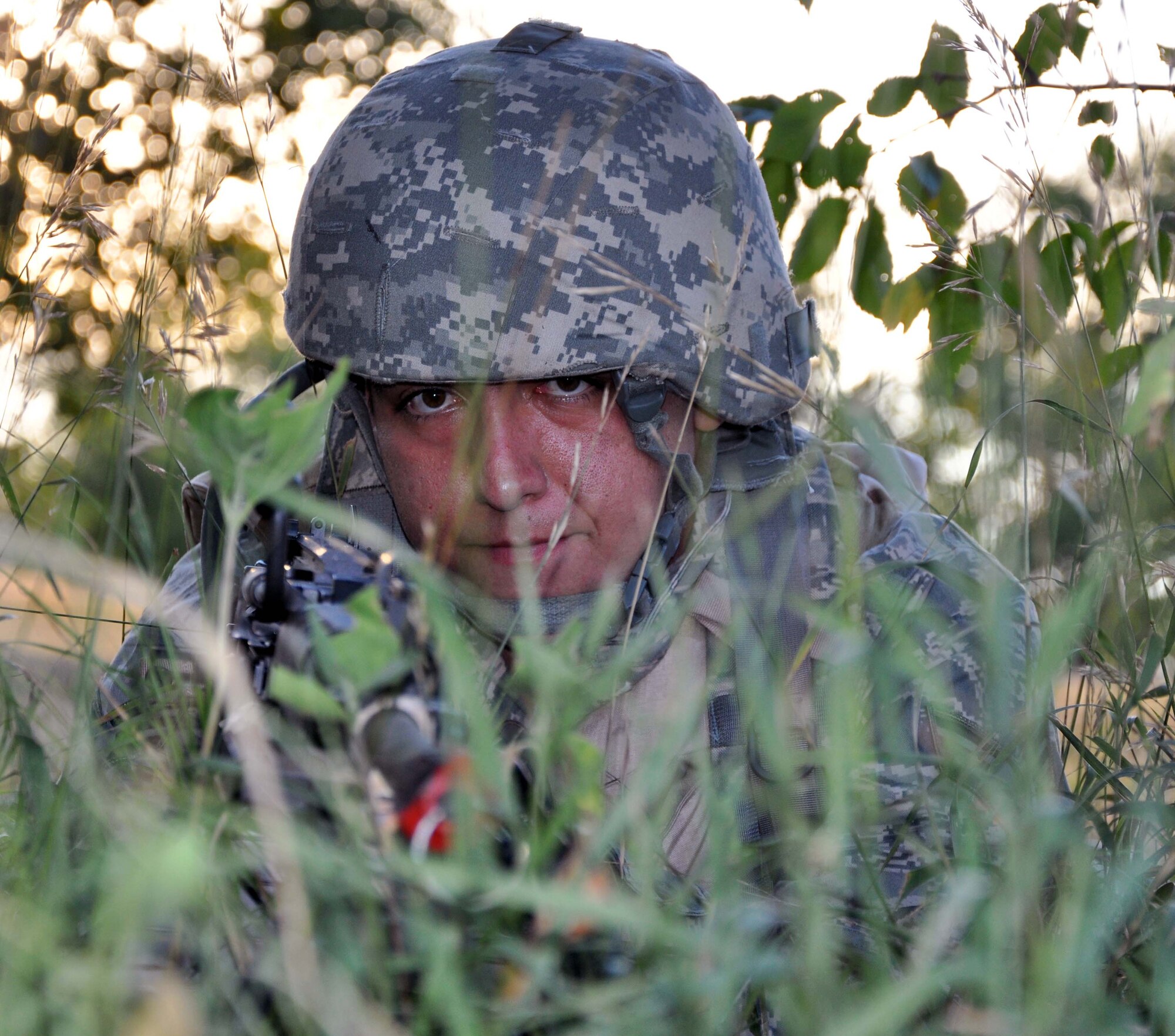 Senior Airman Cody Cox, 931st Security Forces Squadron, sites down the barrel of an M249 light machine gun while taking cover during a field training exercise at McConnell Air Force Base, Kan., August 5, 2012. The 931 SFS conducted a four-day field training exercise to help prepare the squadron for future deployments.  (U.S. Air Force photo by 1st Lt. Zach Anderson)