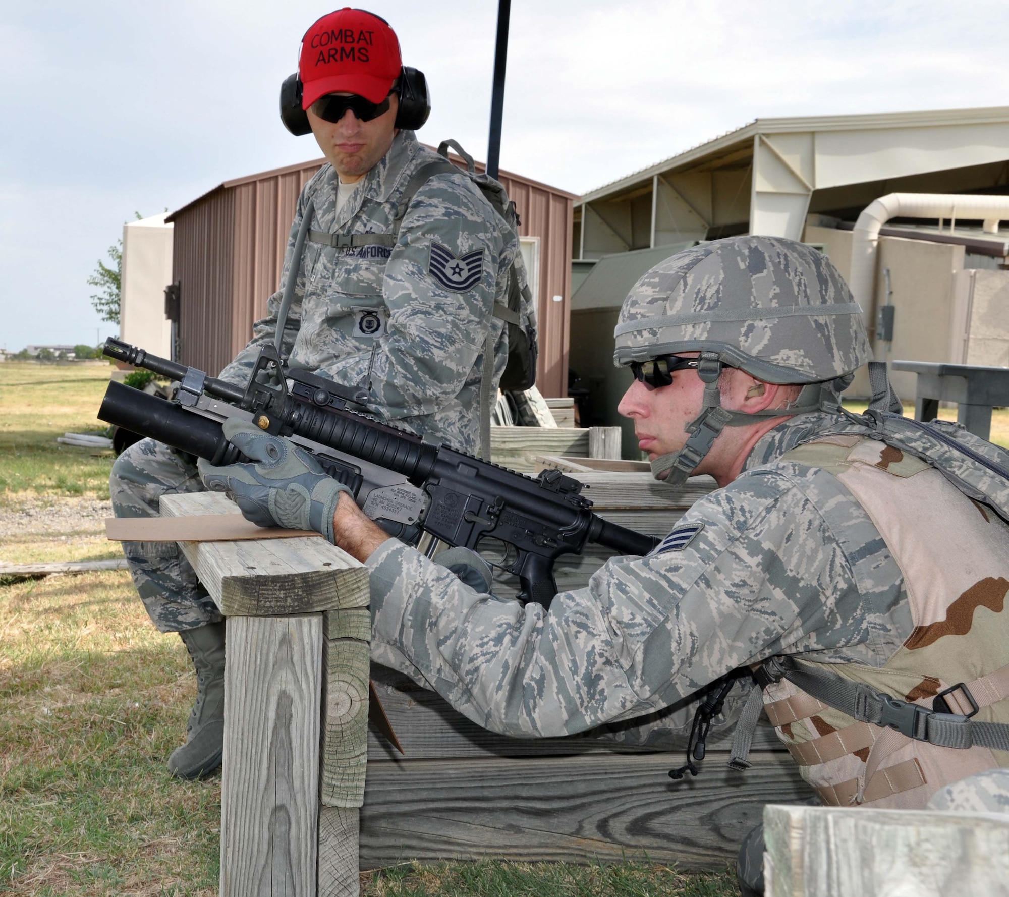 Tech. Sgt. Ryan Jarboe, a Combat Arms Training and Maintenance instructor assigned to the 931st Security Forces Squadron, 931st Air Refueling Group, McConnell Air Force Base, Kan., looks on as Senior Airman Jared Claxton, 931 SFS, fires practice rounds from an M203 grenade launcher during a field training exercise, August 2, 2012.  The four-day exercise was conducted to help prepare the 931 SFS for future deployments. (U.S. Air Force photo by 1st Lt. Zach Anderson)