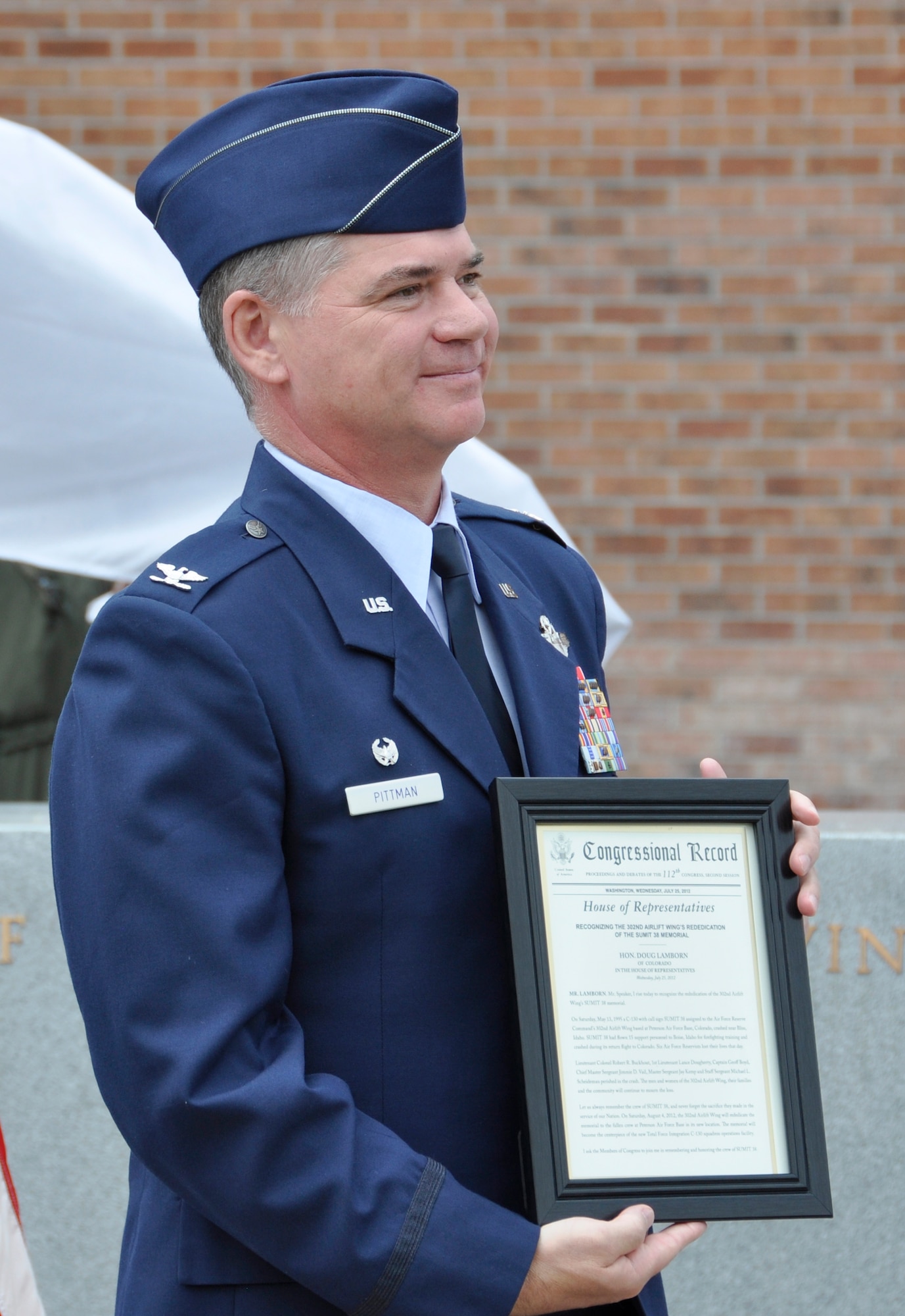 Air Force Reserve Col. Jay Pittman, 302nd Airlift Wing commander, showcases the Congressional Record read on the floor of the U.S. House of Representatives honoring the re-dedication of the wing’s ‘Sumit 38’ memorial Aug. 4, 2012, at Peterson Air Force Base, Colo.  Pittman, who presided over the ceremony, ushered in the re-dedication of the memorial which honors the six AF Reservists who perished during the crash of a C-130 Hercules on May 13, 1995. The memorial was re-dedicated with family members of the fallen and 302nd Airlift Wing and 52nd Airlift Squadron members present. The memorial was moved from its previous location as part of the wing’s expansion under the Total Force Initiative framework. The Airmen who were killed when their aircraft crashed approximately 60 miles southeast of Mountain Home, Idaho, are: Lt. Col. Robert Buckhout; Capt. Geoffrey Boyd; 1st Lt. Lance Dougherty; Chief Master Sgt. Jimmie Vail; Master Sgt. Jay Kemp; and Staff Sgt. Michael Scheideman. (U.S. Air Force photo/Staff Sgt. Stephen J. Collier)
