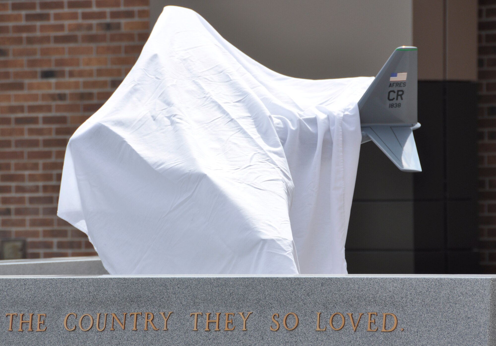 A model of ‘Sumit 38,’ an Air Force Reserve C-130 Hercules that crashed in May 1995, remains covered before being re-dedicated during an Aug. 4, 2012, ceremony at Peterson Air Force Base, Colo. The memorial, which honors the six AF Reservists who perished during the crash, was re-dedicated with family members of the fallen and 302nd Airlift Wing and 52nd Airlift Squadron members present. The memorial was moved from its previous location as part of the wing’s expansion project under the Total Force Initiative framework. The Airmen who were killed when their aircraft crashed approximately 60 miles southeast of Mountain Home, Idaho, are: Lt. Col. Robert Buckhout; Capt. Geoffrey Boyd; 1st Lt. Lance Dougherty; Chief Master Sgt. Jimmie Vail; Master Sgt. Jay Kemp; and Staff Sgt. Michael Scheideman. (U.S. Air Force photo/Staff Sgt. Stephen J. Collier)
