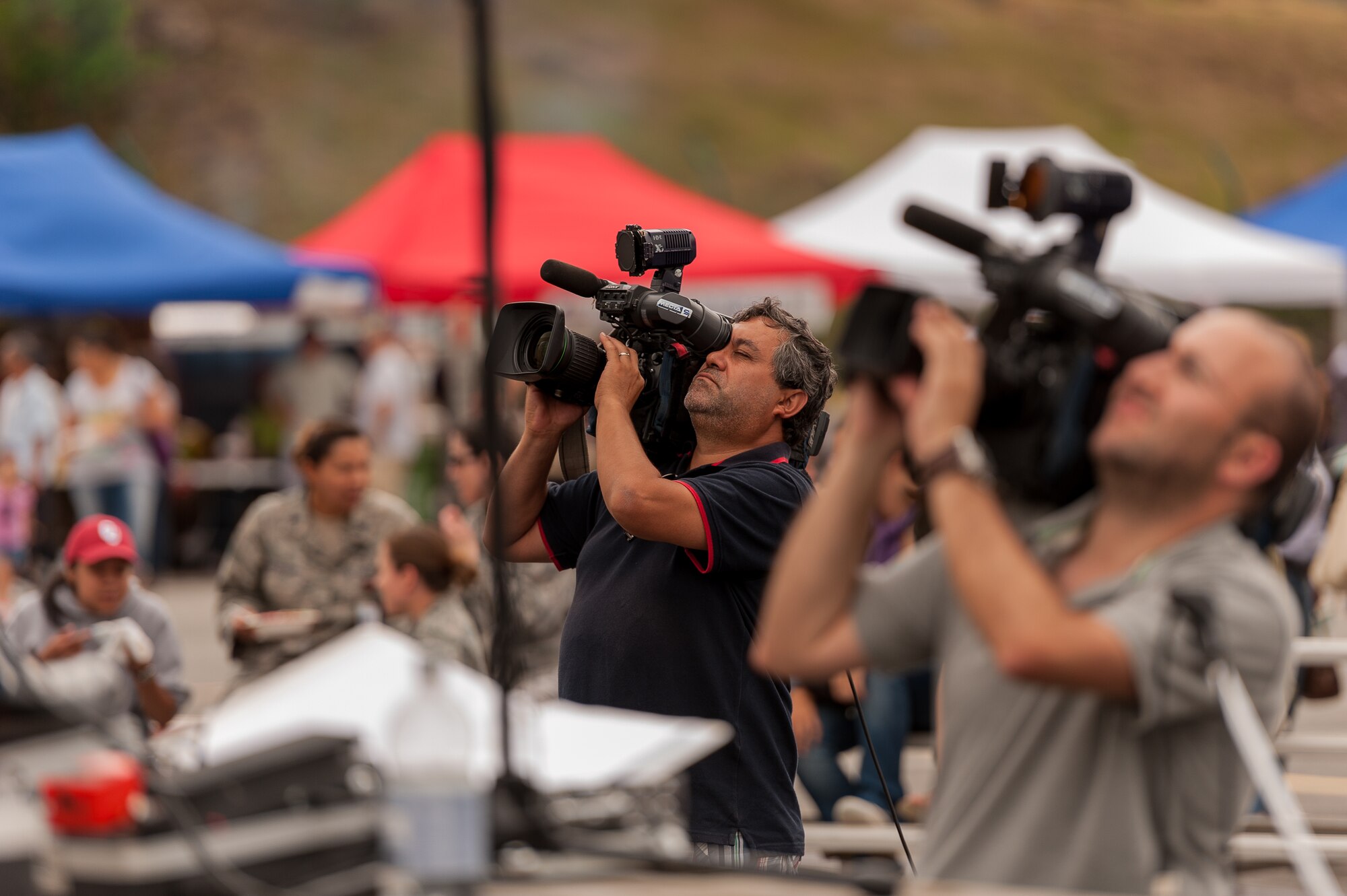 Local media captures footage during the 2012 Open House for RTP-Açores Daily News, at Lajes Field, Aug. 5, 2012.  The Open House provided an opportunity for Team Lajes to showcase our military readiness and capabilities to our local community.  The event featured various activities including a mini bazaar, military working dog demonstrations, aircraft displays and  live performances by Rock After Midnight (R.A.M) and the USAFE Band, Touch ‘n Go.  (Photo by Lucas Silva)