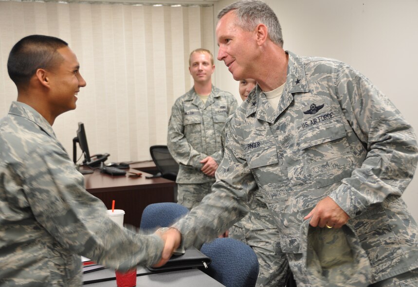 Airman Basic Marco Gaona, 73rd Aerial Port Squadron air transportation journeyman, receives a coin from Brig. Gen. William B. Binger, 10th Air Force commander, during a tour of the squadron, Saturday, Aug. 4.The August unit training assembly was the Airman's first to participate in. The 73rd APS tour was in conjunction with the 301st Fighter Wing visit. The tour was led by Brig. Gen. Ronald B. Miller, 301st Fighter Wing commander, and unit officers. (U.S. Air Force photo/SrA Melissa Harvey)