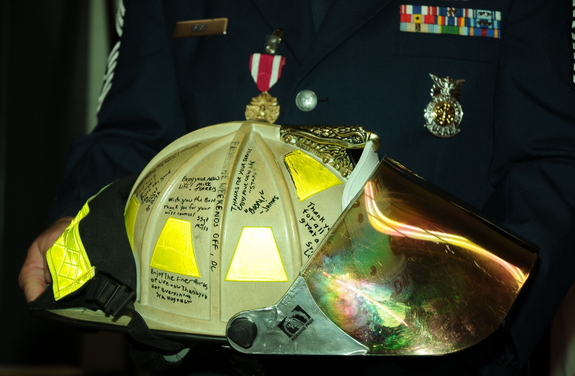 Chief Master Sgt. Michael Baize, 512th Civil Engineer Squadron fire chief, holds a helmet signed by members of the 512th CES given to him during the his retirement ceremony at Firehouse 2 on Dover AFB, Del. Aug. 4, 2012. Liberty Wing fire department members stood in formation during the ceremony that was attended by the chief's family, friends and fellow Airmen. (U.S. Air Force photo/Staff Sgt. Andria J. Allmond)