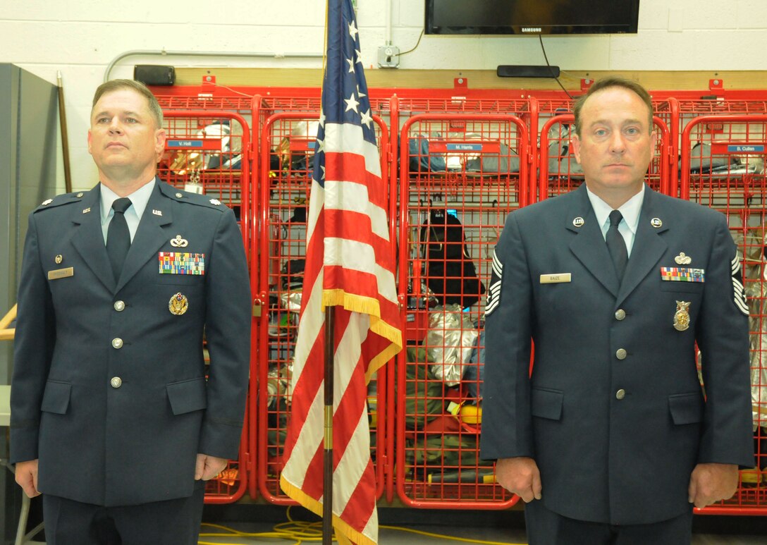Lt. Col. Richard Freewalt, 512th civil engineer squadron commander, and Chief Master Sgt. Michael Baize, 512th CE fire chief, stand at attention during a retirement ceremony for the chief at Firehouse 2 on Dover Air Force Base, Del. Aug. 4, 2012. The chief's retirement closes out a 26-year career complied within the Air National Guard and Air Force Reserve Command. (U.S. Air Force photo/Staff Sgt. Andria J. Allmond)