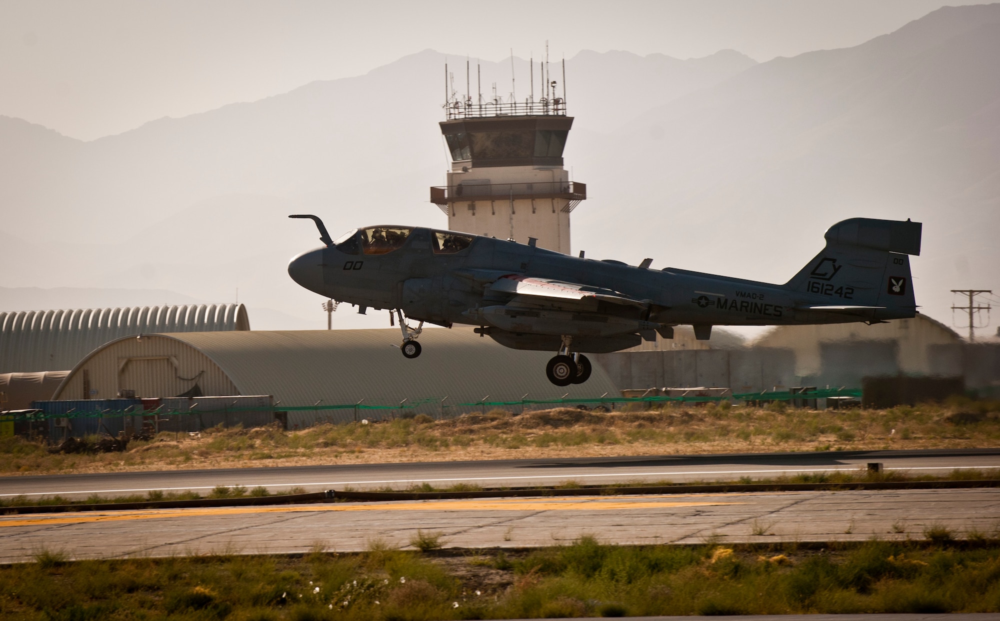 A U.S. Marine Corps EA-6B 2 Prowler with Marine Tactical Electronic Warfare Squadron-2 passes the control tower at Bagram Airfield, Afghanistan, 2 August, 2012. In a fight where the enemy is updating their unconventional tactics, having a dedicated electronic warfare platform keeping watch over coalition forces can prove vital and the Marines of VMAQ-2 are well equipped to meet this mission. (U.S. Air Force Photo/Capt. Raymond Geoffroy)