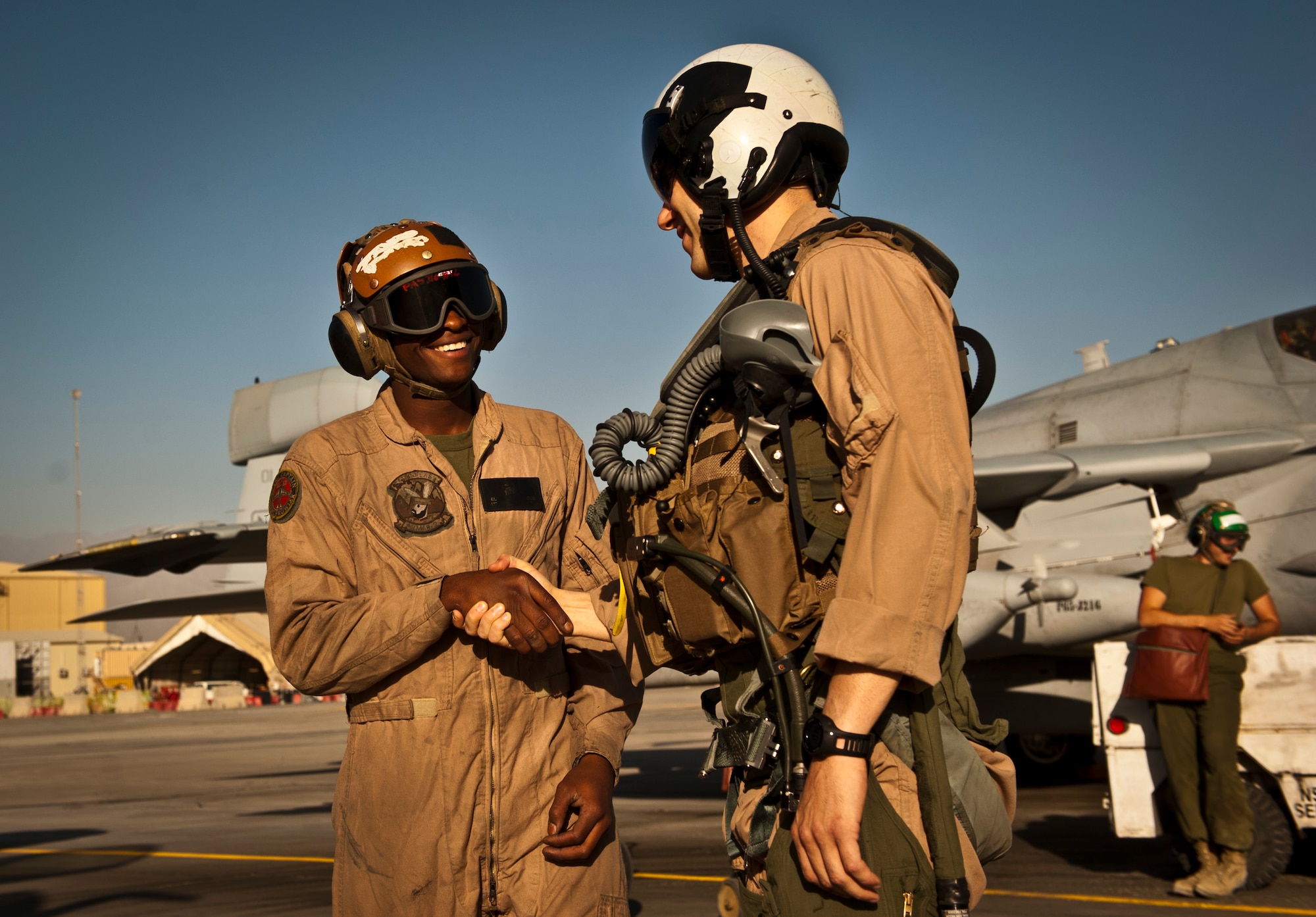 Marine Capt. Dan Gibbon, a pilot assigned to Marine Tactical Electronic Warfare Squadron-2, and Lance Corporal Calvin Spears, an EA-6B Prowler Plane Captain with VMAQ-2, shake hands before a mission at Bagram Airfield, Afghanistan, 2 August, 2012. VMAQ-2 supports coalition forces in Afghanistan by interrupting enemy electronic activity in the combat area. (U.S. Air Force Photo/Capt. Raymond Geoffroy)