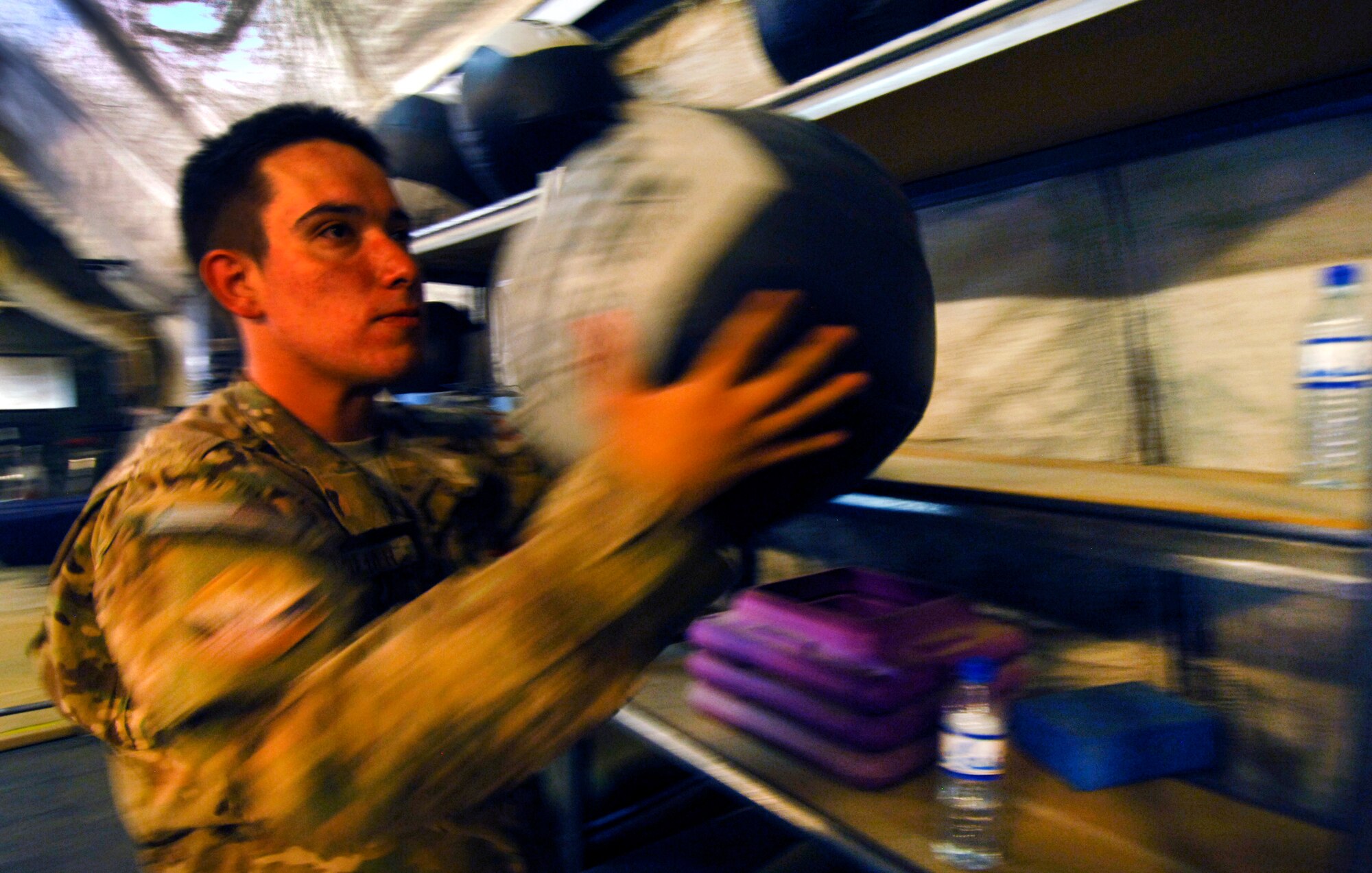 SrA Aaron Oliver, 22nd Special Tactics Squadron radio support technician, picks up a medicine ball at the Pebble Gym at Bagram Airfield, Afghanistan, Aug. 2, 2012. During his deployment to BAF, Oliver has lost 47 pounds by eating correctly and alternating his exercises. Oliver gave credit to his leadership for inspiring him to lose weight. (U.S. Air Force photo/SSgt Jeff Nevison)