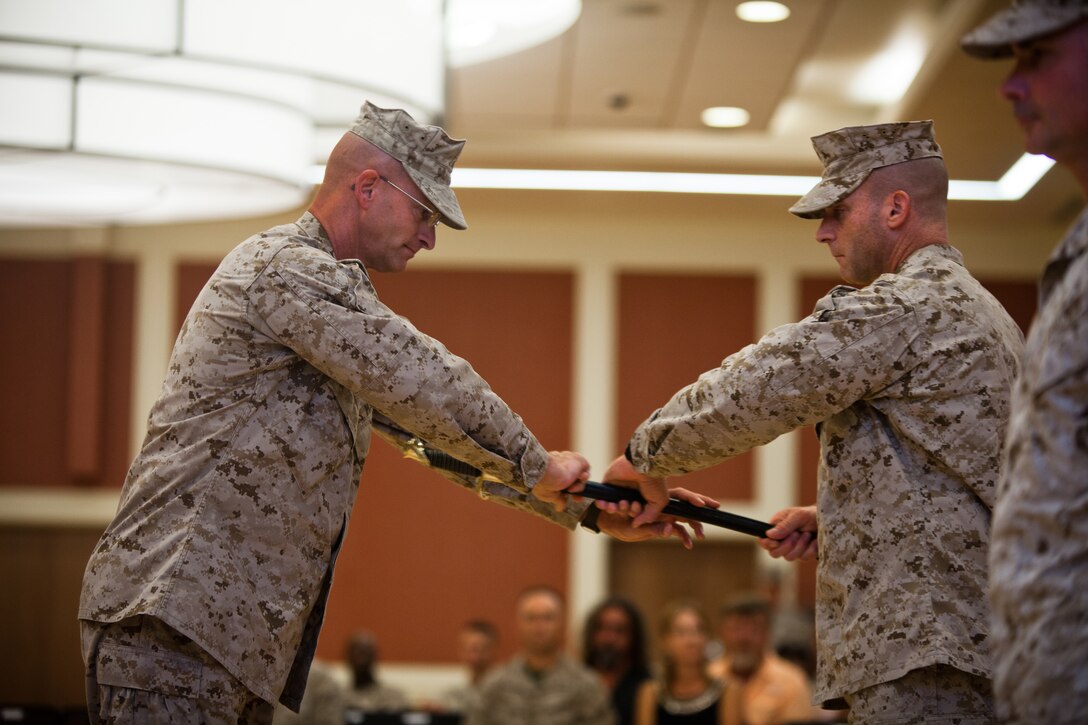 Sergeant Maj. Joseph D. Shaw, the incoming sergeant major of II Marine Expeditionary Force Headquarters Group, receives the sword of office from Col. James B. Stopa, the commanding officer of II MHG, during a relief and appointment ceremony at Camp Lejeune, Aug. 2. Shaw recently served as the sergeant major of 2nd Marine Division (Forward) while it deployed to Helmand Province, Afghanistan as Task Force Leatherneck in support of Operation Enduring Freedom. 