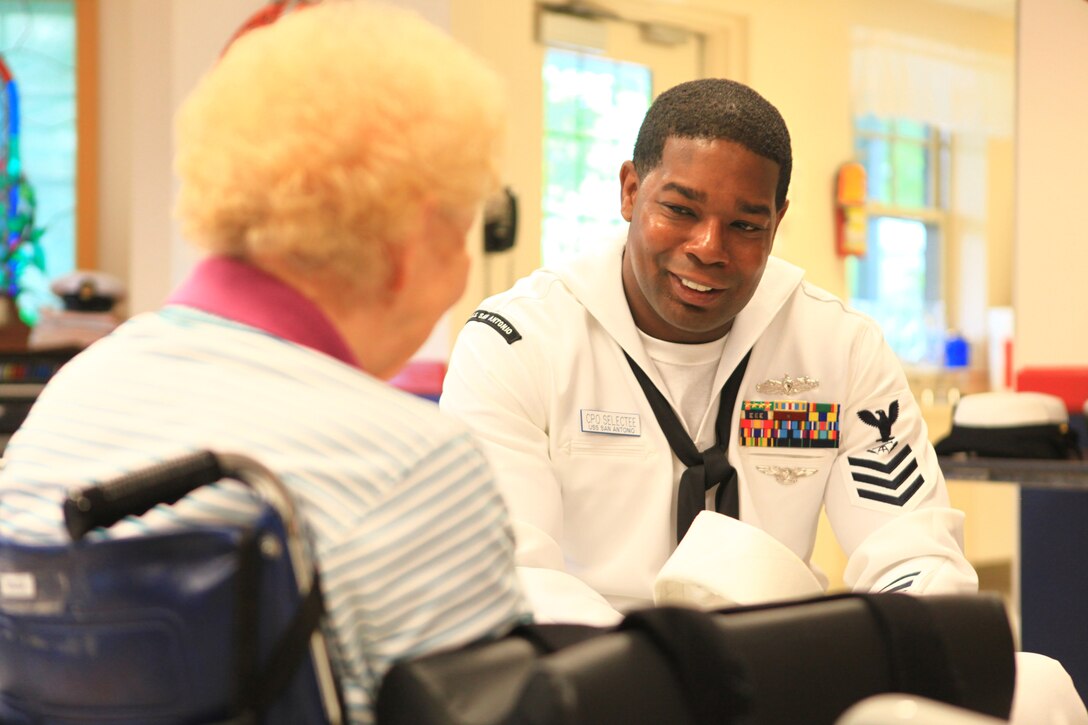 Chief Petty Officer (Select) Jaybee Grisson, a fire control man on the USS San Antonio with more than 19 years of naval service, talks to a resident at the Knox Center, a nursing facility in Rockland, Maine, during the 2012 Lobster Festival, Aug. 2, 2012. The crew aboard the San Antonio joined with nearly 100 Marines and sailors from Combat Logistics Regiment 27, 2nd Marine Logistics Group to interact with the people of Maine. More than 25 servicemembers visited the nursing facility in order to bring the festivities to its residents. (Photo by Lance Cpl. Paul Peterson)