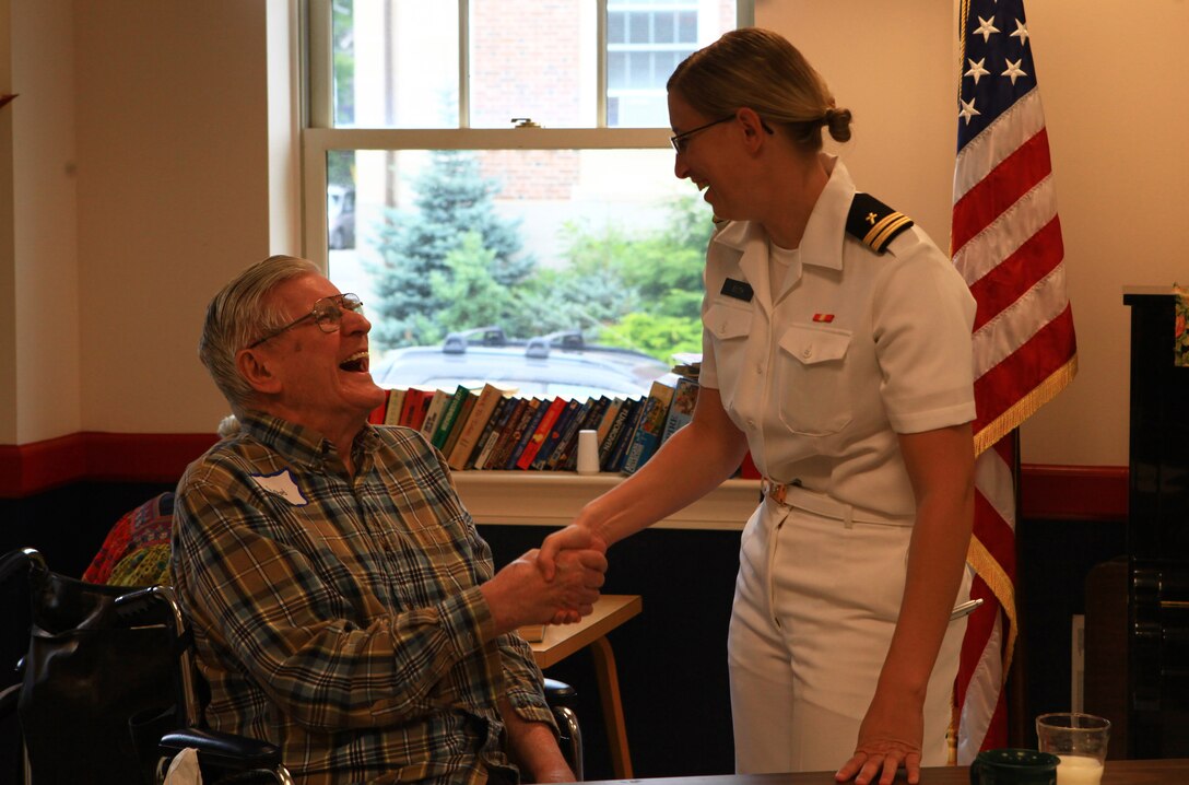 Navy Lt. Tiffany Smith, a chaplain candidate program officer working with the Marines and sailors aboard the USS San Antonio, greets a resident at the Knox Center, a nursing facility in Rockland, Maine, during the 2012 Lobster Festival Aug. 2, 2012. Smith helped lead more than 25 Marines and sailors from the San Antonio and Combat Logistics Regiment 27, 2nd Marine Logistics Group to engage the facility’s residents during the festival.  (Photo by Lance Cpl. Paul Peterson)