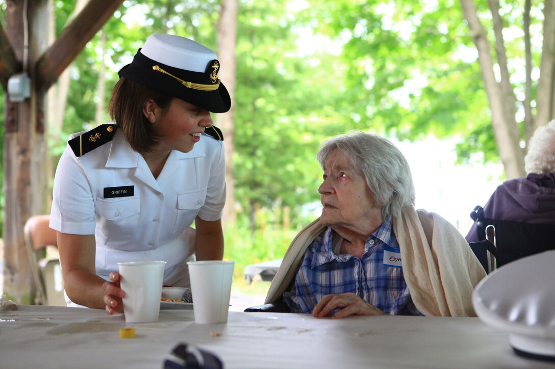 Midshipman 3rd Class Cynthia Griffin of the USS San Antonio delivers a beverage to a resident of Knox Center, a long-term care nursing facility in Rockland, Maine, during a community relations visit Aug. 2, 2012.  More than 25 Marines and sailors from Combat Logistics Regiment 27, 2nd Marine Logistics Group and the San Antonio’s crew visited the long-term care nursing facility.  (Photo by Lance Cpl. Paul Peterson)