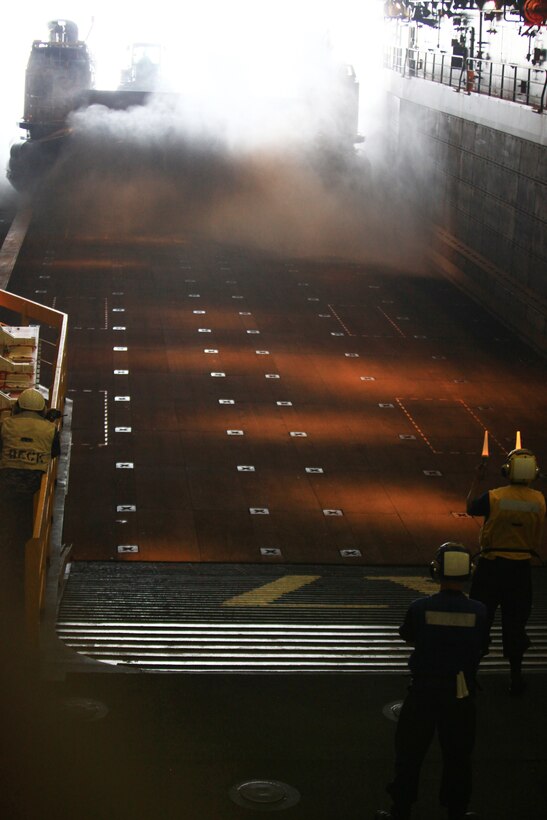 A Landing Craft Air Cushion carries vehicles aboard the USS San Antonio off the coast of Virginia and surges water into the docking bay the morning of July 30, 2012. The LCAC and its cargo are all part of a combined Marine-Navy demonstration, which includes Marines and sailors from Combat Logistics Regiment 27, 2nd Marine Logistics Group bound for Maine’s 2012 Lobster Festival. (Photo by Lance Cpl. Paul Peterson) 