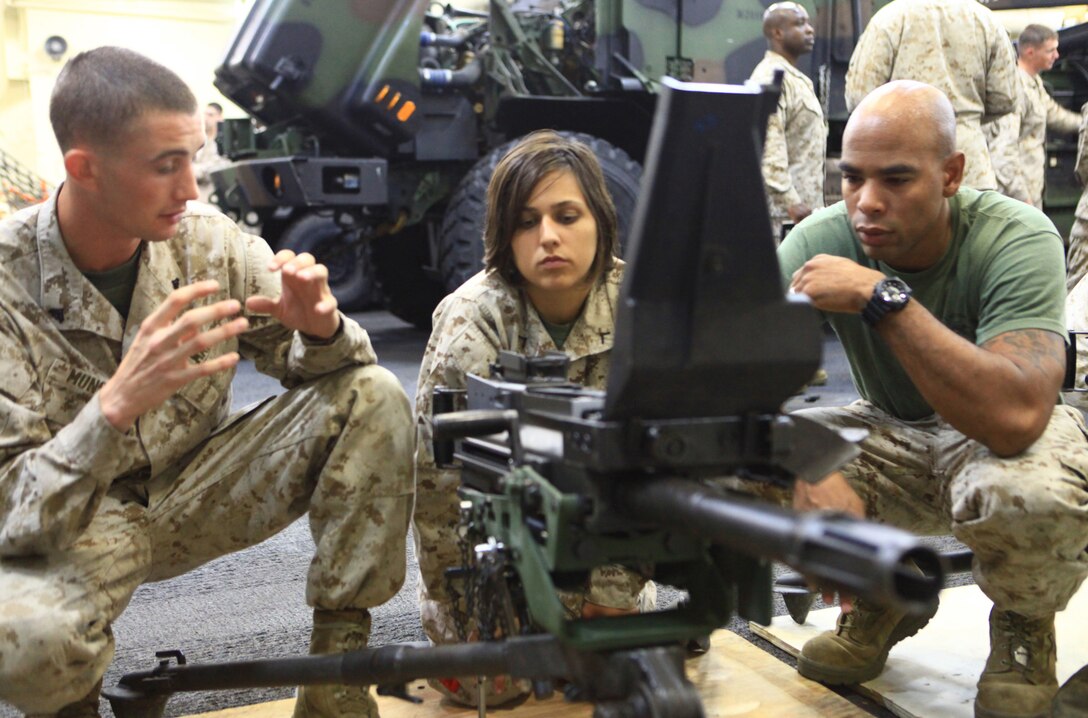 Cpl. Austin Mundis (left), a combat engineer with Combat Logistics Battalion 22, 2nd Marine Logistics Group, reviews the functioning parts of the Mark 19 Grenade Launcher with Pfc. Abigail Reynolds (center) and Cpl. Justin Wilson (right), all with the 2012 Lobster Festival detachment, aboard the USS San Antonio prior to their arrival in Rockland, Maine, July 31, 2012. Teams of Marines and sailors will guide visitors through the various weapons platforms used by the Marine-Navy team as part of the festival’s activities. (Photo by Lance Cpl. Paul Peterson)
