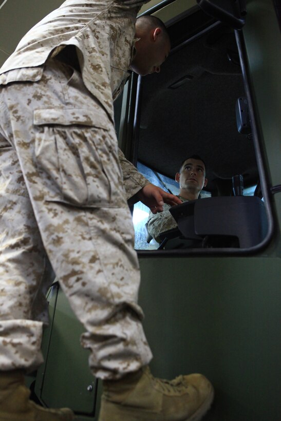 Staff Sgt. Christopher Stephens, a landing support specialist with Combat Logistics Regiment 27, 2nd Marine Logistics Group, sits and reviews the controls of a multi-purpose tractor with Cpl. Aaron Good, a heavy equipment operator with Combat Logistics Battalion 22, 2nd Marine Logistics group, aboard the USS San Antonio on its way to Rockland, Maine, July 31, 2012. The Marines and sailors are part of the 2012 Lobster Festival detachment sent to give the American people a first-hand view of the combined Marine-Navy capabilities. (Photo by Lance Cpl. Paul Peterson)