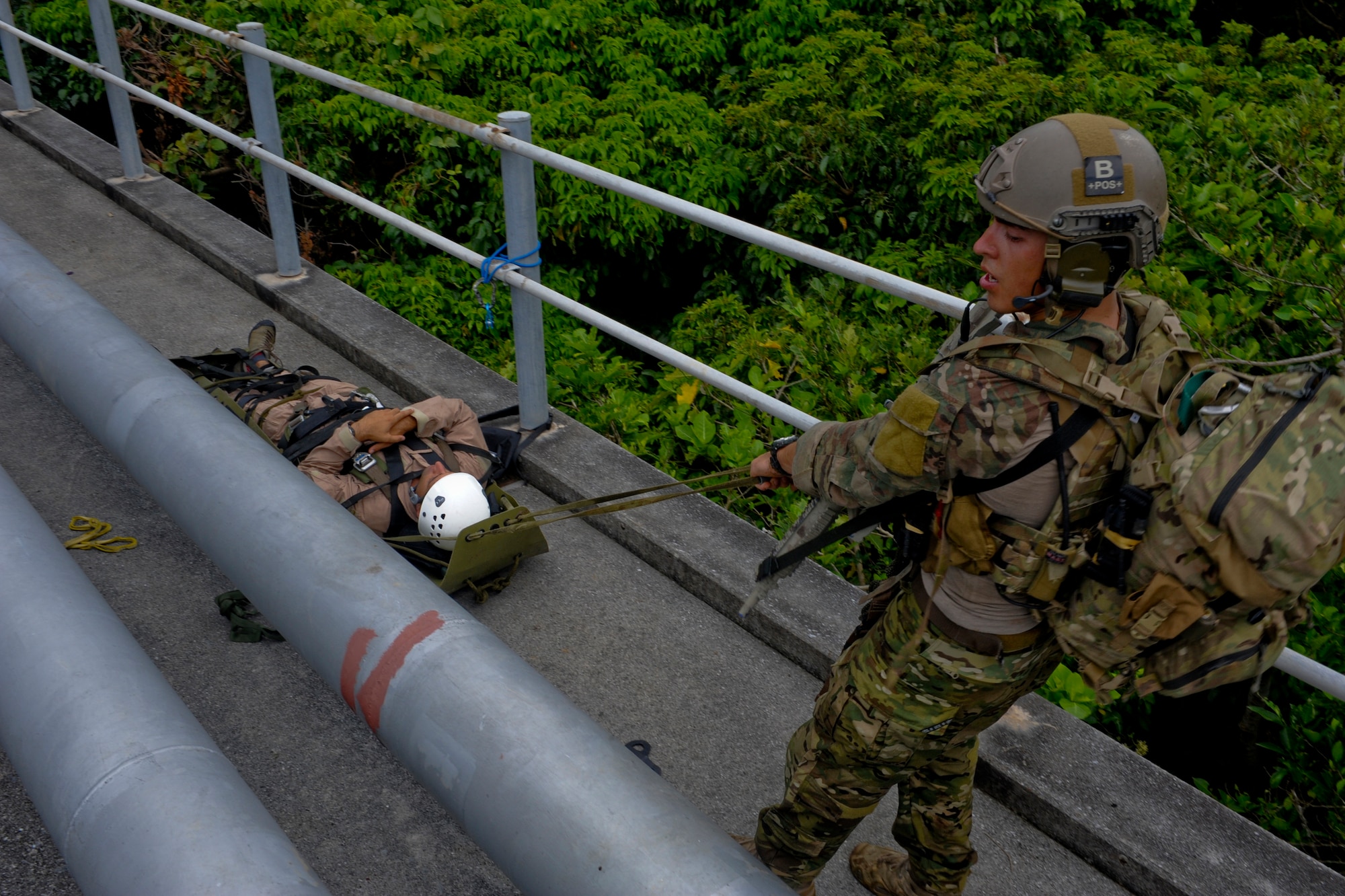 U.S. Air Force Senior Airman Kristofer Felix, 31st Rescue Squadron pararescueman, pulls an isolated mock victim to a safety point during a technical rescue element leader upgrade scenario on Kadena Air Base, Japan, Aug. 3, 2012. This upgrade training evaluates a pararescuemen's ability to transition from being a part of the group to leading the group. (U.S. Air Force photo/Airman 1st Class Justin Veazie)