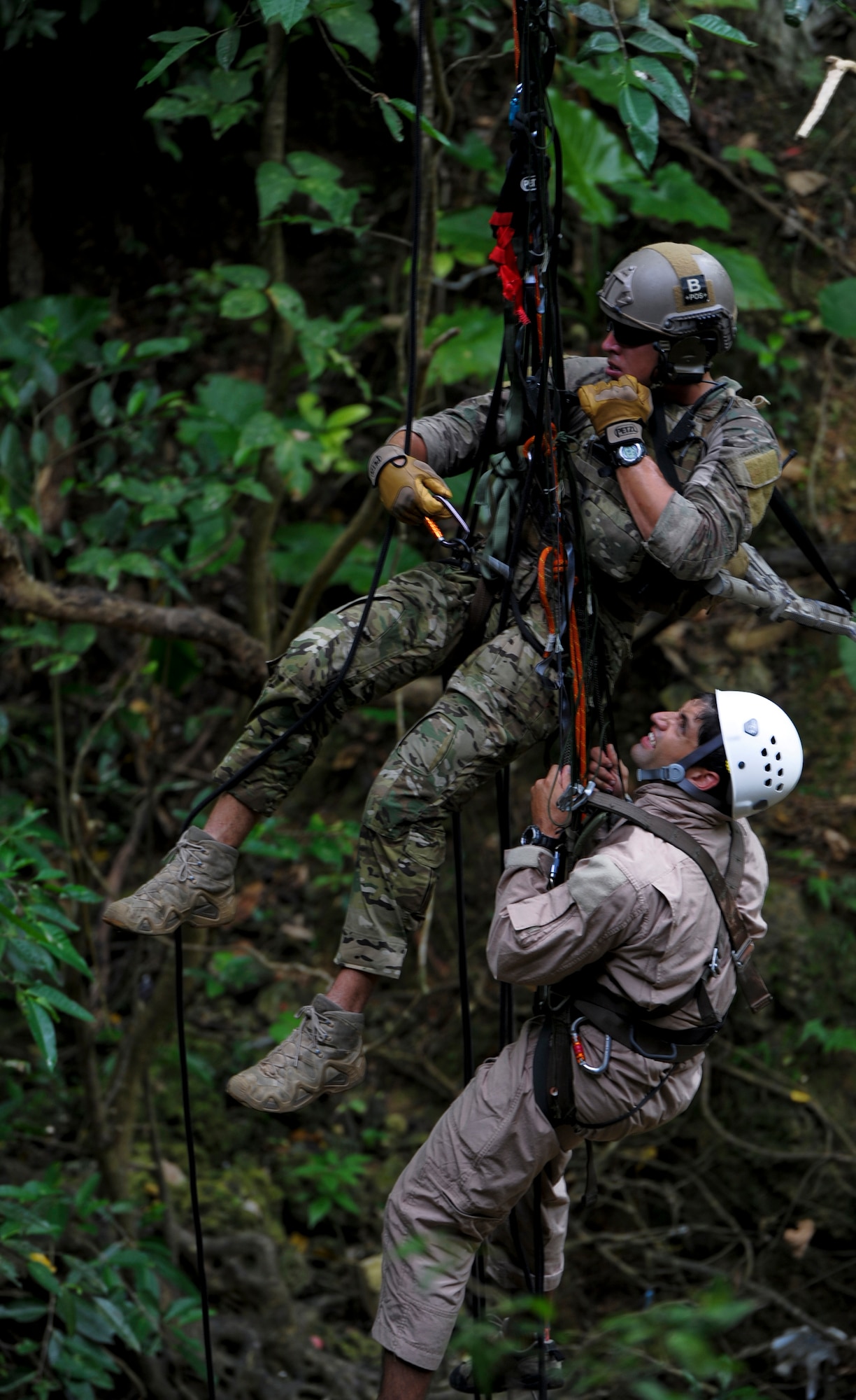 U.S. Air Force Senior Airman Kristofer Felix, 31st Rescue Squadron pararescueman, reaches a mock victim and immediately starts clamping him into a harnesses during a technical rescue element leader upgrade scenario on Kadena Air Base, Japan, Aug. 3, 2012.  This upgrade training evaluates a pararescuemen's ability to transition from being a part of the group to leading the group. (U.S. Air Force photo/Airman 1st Class Justin Veazie)