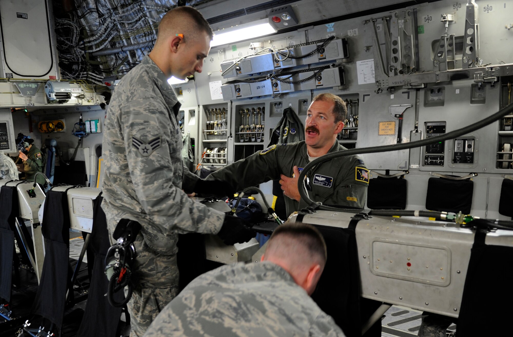 Alaska Air National Guard Capt. Brian Marasco, 249th Airlift Squadron, talks with Senior Airman Ryan Beck, 703rd Aircraft Maintenance Squadron, as members of the 703rd AMXS work to ready the seats in a C-17 Globemaster III Aug. 3, 2012, prior to a flight to Hill Air Force Base, Utah. The combined Alaska ANG and JBER active-duty aircrew provided a team of JBER reservists airlift to Hill so they could participate in the upcoming Combat Hammer exercise. (U.S. Air Force photo/Tech. Sgt. Brian Ferguson)