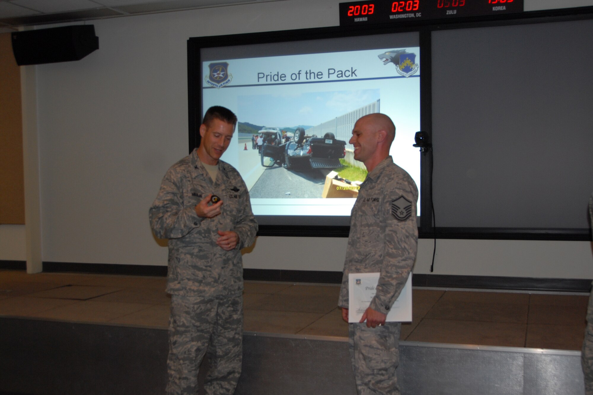 Col. Douglas Nikolai, 8th Fighter Wing vice commander, presents Master Sgt. Ryan Kohler, 8th Communications Squadron, with a Pride of the Pack award Aug. 2, 2012. (U.S. Air Force photo/Capt. Sheila Johnston)