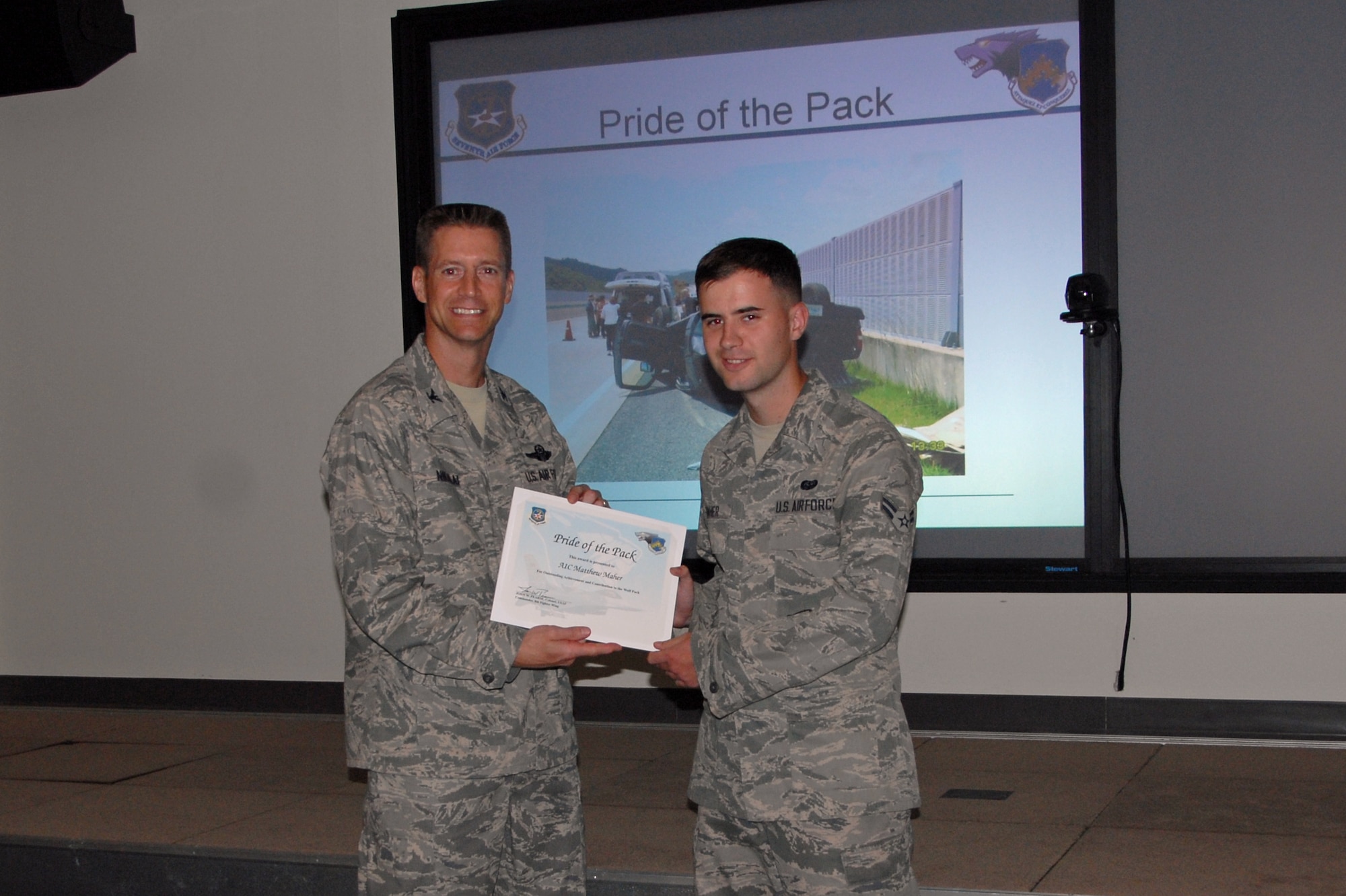 Col. Douglas Nikolai, 8th Fighter Wing vice commander, presents Airman 1st Class Matthew Mayer, 8th Communications Squadron, with a Pride of the Pack award Aug. 2, 2012. (U.S. Air Force photo/Capt. Sheila Johnston)
