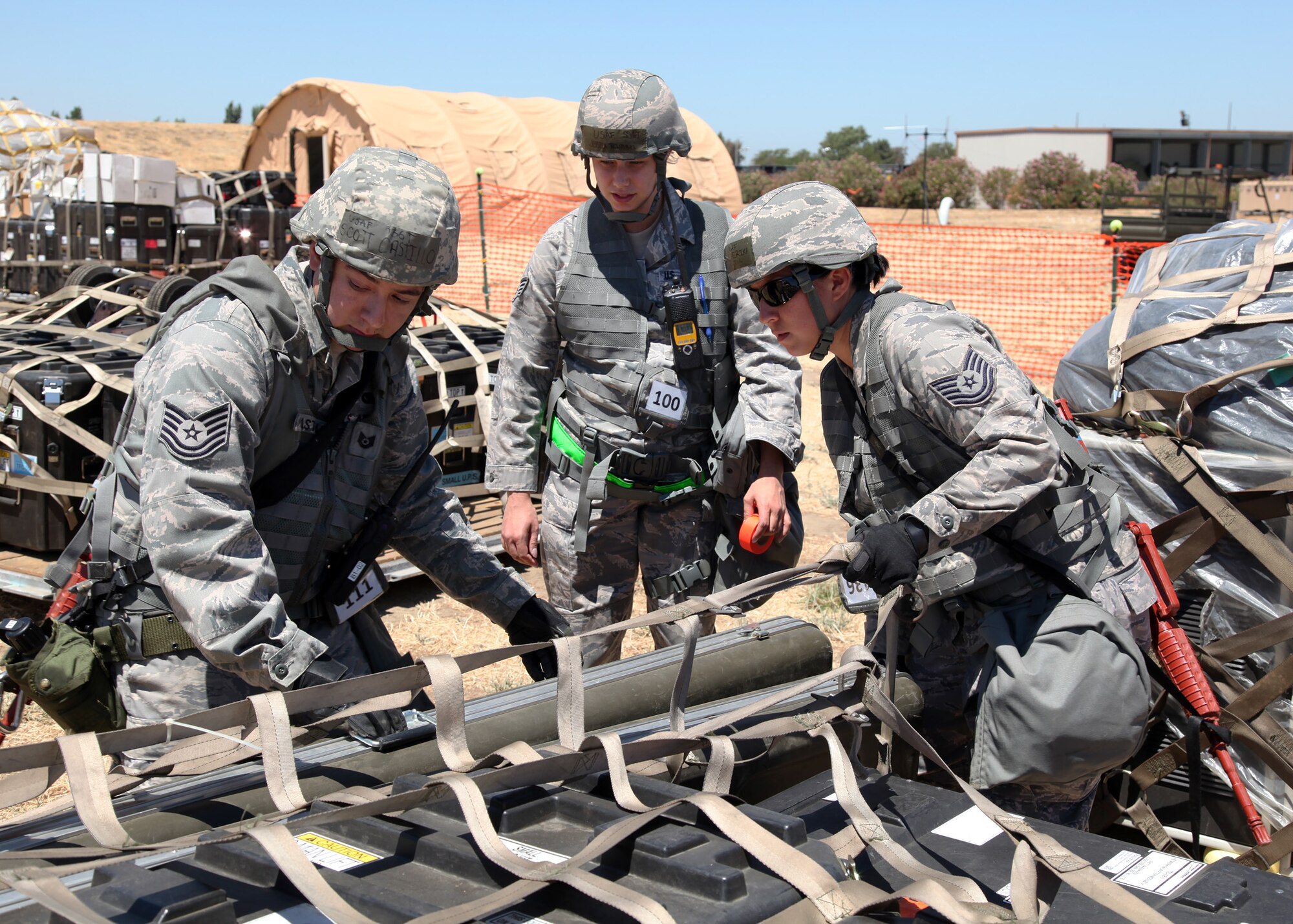 TRAVIS AIR FORCE BASE, Calif. -- Tech. Sgt. Scott Castillo (left), Staff Sgt. Jessica Trimble, and Tech. Sgt. Erika Victor, members of the 23rd Combat Communications Squadron practice organizing cargo pallets as part of an operational readiness exercise July 9, 2012 at Travis Air Force Base, Calif. (U.S. Air Force photo / Lt. Col. Robert Couse-Baker)