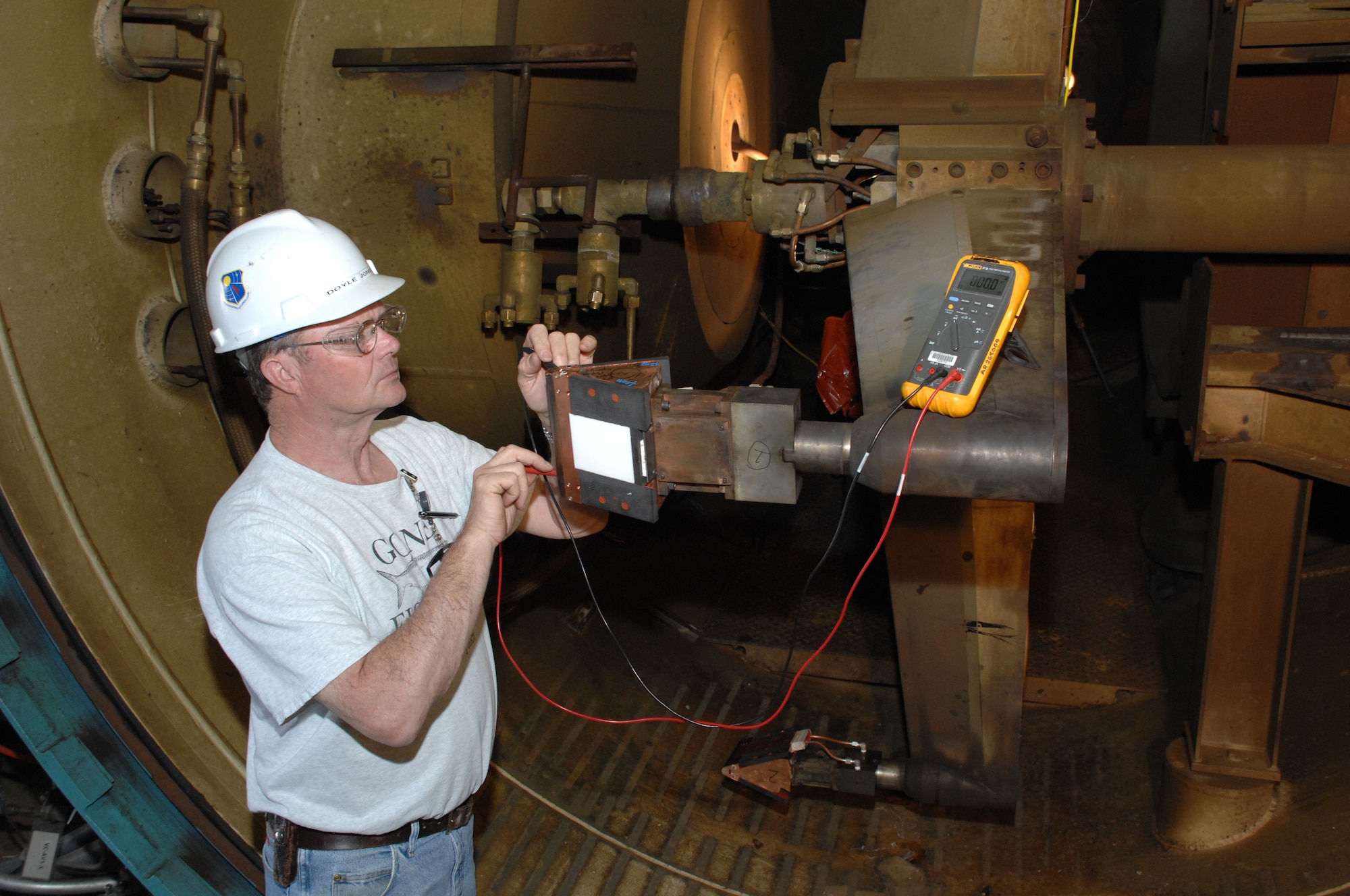 Aerospace Testing Alliance Instrumentation Technician Doyle Jones performs a continuity check on the instrumentation inside the Orion Crew Exploration Vehicle heat shield material candidate model prior to a test run in Arnold Engineering Development Center's H2 test facility. (Photo by Rick Goodfriend)