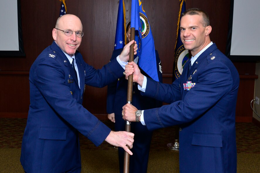 Col. Jim Fisher, National Reconnaissance Office director of the Office of Space Launch, passes the NRO Operations Squadron guidon to Lt. Col. Chad Davis during the change of command ceremony July 18. (Courtesy photo)
