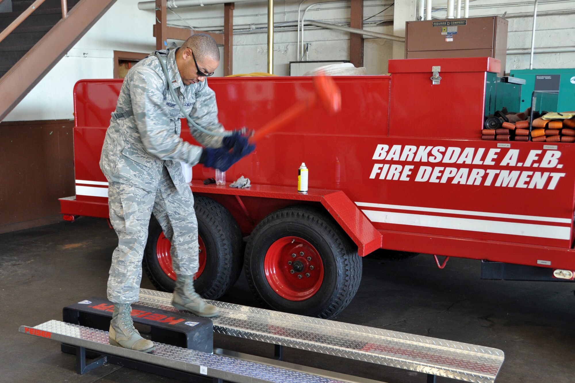 Chaplain Candidate 2nd Lt. James Moore, uses a sledge hammer on a Kieser Sled during a tour of the Fire Department in Hangar 3 at Barksdale Air Force Base, La., July 31, 2012. The use of the sledge hammer simulates the hacking into a roof with an axe. (U.S. Air Force photo by Master Sgt. Jeff Walston)