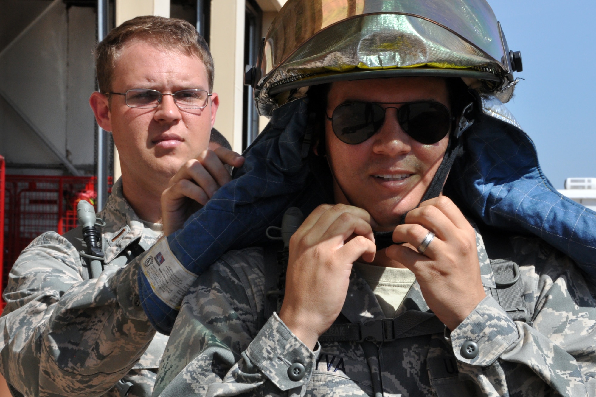 Chaplain Candidate 2nd Lt. Callen Davis helps 2nd Lt. Yandy Leyva gear up for a firefighting demonstration at Barksdale Air Force Base, La., July 31, 2012. Both Airmen, who are part of The Chaplain Candidate Intensive Internship program, were on a tour of the fire department at Barksdale. (U.S. Air Force photo by Master Sgt. Jeff Walston)