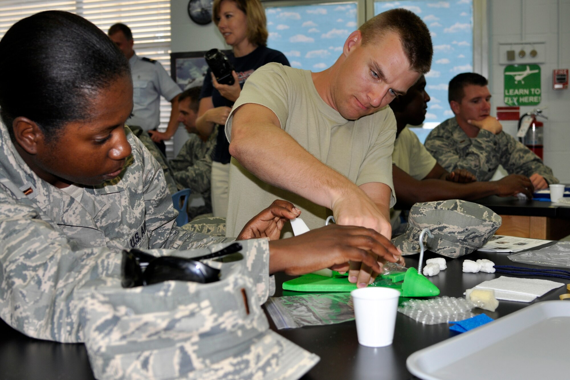 Chaplain Candidates, 2nd Lt. Tosha James and 2nd Lt. Steven Wichern build a new ride for Eggbert at STARBASE Louisiana on Barksdale Air force Base, La., July 30, 2012. The purpose of the teamwork exercise is designed to get people to work together mentally designing a way to keep an egg from breaking. (U.S. Air Force photo by Betty Stephens)