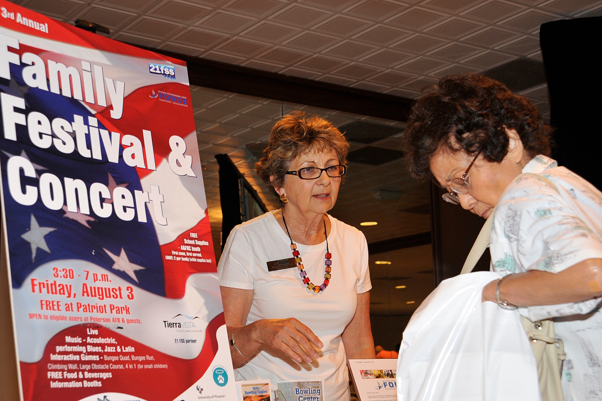 PETERSON AIR FORCE BASE, Colo. -- Margie Arnold (left), 21st Force Support Squadron, provides information to an attendee during Retiree Appreciation Day in The Club July 28, 2012. The day is held annually to provide retirees in the Colorado Springs area with information on base services and agencies. (U.S. Air Force photo/Dennis Howk)