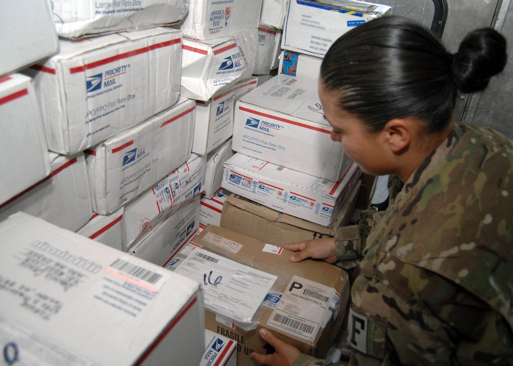 U.S. Air Force Staff Sgt. Daida Garcia-Ortiz, 451st Expeditionary Security Forces Squadron mail augmentee, stacks packages in the back of the mail truck July 31. Augmentees from each air expeditionary group rotate weekly to assist the 451st Air Expeditionary Wing mail clerk. (U.S. Air Force photo/Master Sgt. James Martin/RELEASED