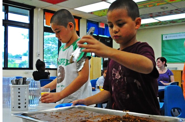 Children grab an afternoon snack while attending Cheli School-Age Program at Misawa Air Base, Japan, Aug. 6, 2012.  The program is available to children ages 5 to 12 years old and offers full-time care during the summer and before and after care during the school year.  (U.S. Air Force photo by Staff Sgt. April Quintanilla)