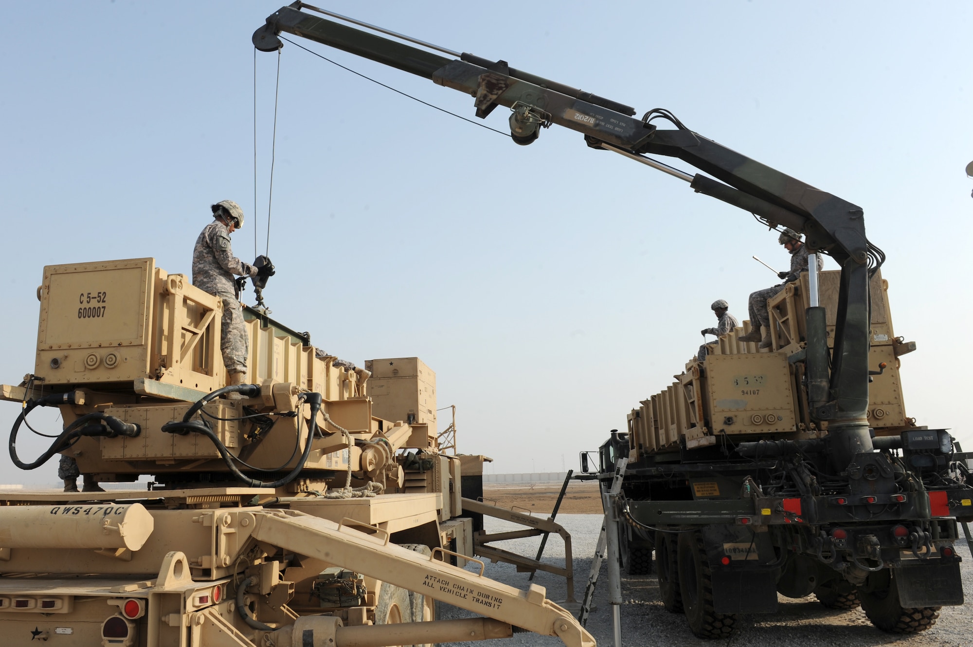 SOUTHWEST ASIA - Members of the 1st Battalion, 7th Air Defense Artillery Regiment, transfer canisters during a missile reload certification Aug. 4, 2012. The five-solider missile reload team must reload a heavy expandable mobile tactical truck with four new canisters within an hour to be considered proficient.  (U.S. Air Force photo/Master Sgt. Scott MacKay)