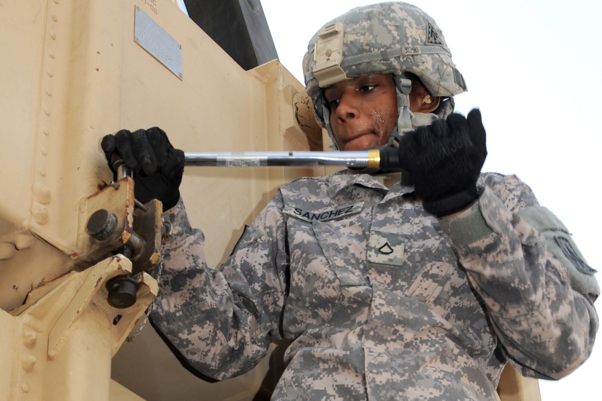 SOUTHWEST ASIA - Sweat beads on the face of U.S. Army Pfc. Tiffany Sanchez, crew member tag, as she tightens a canister in place during a missile reload certification Aug. 4, 2012. Sanchez is part of the 1st Battalion, 7th Air Defense Artillery Regiment deployed from Fort Bragg, N.C.  (U.S. Air Force photo/Master Sgt. Scott MacKay)